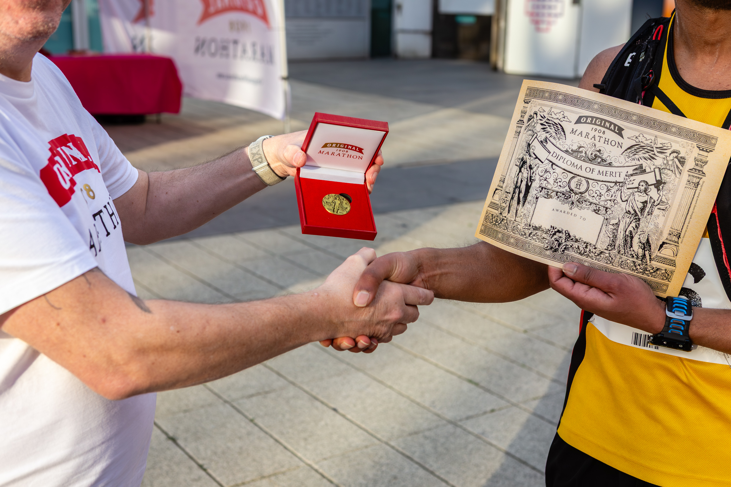 Close up of person awarding a marathon running with a medal and certificate