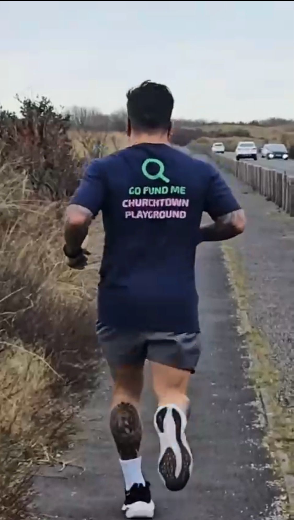 Back of man who is running alongside a main road in England