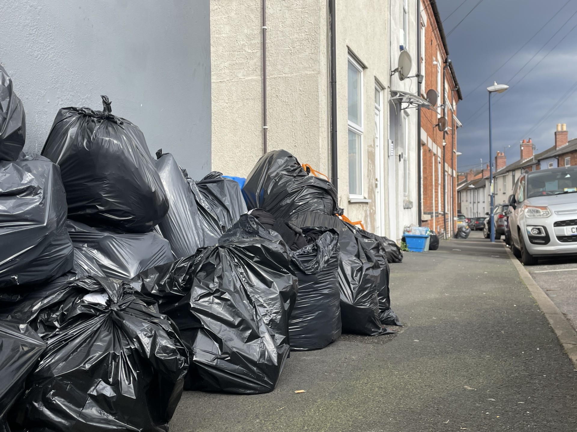 Black bin liners on a street full of uncollected rubbish