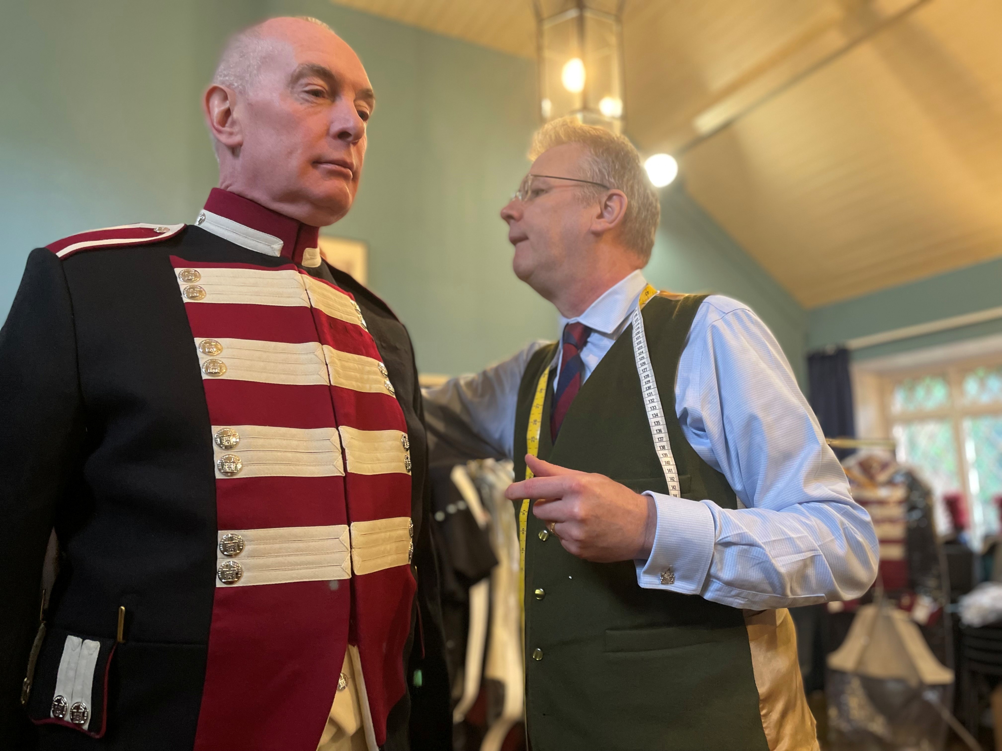 A member of the Hillsborough Fort Guard has his uniform checked by a tailor