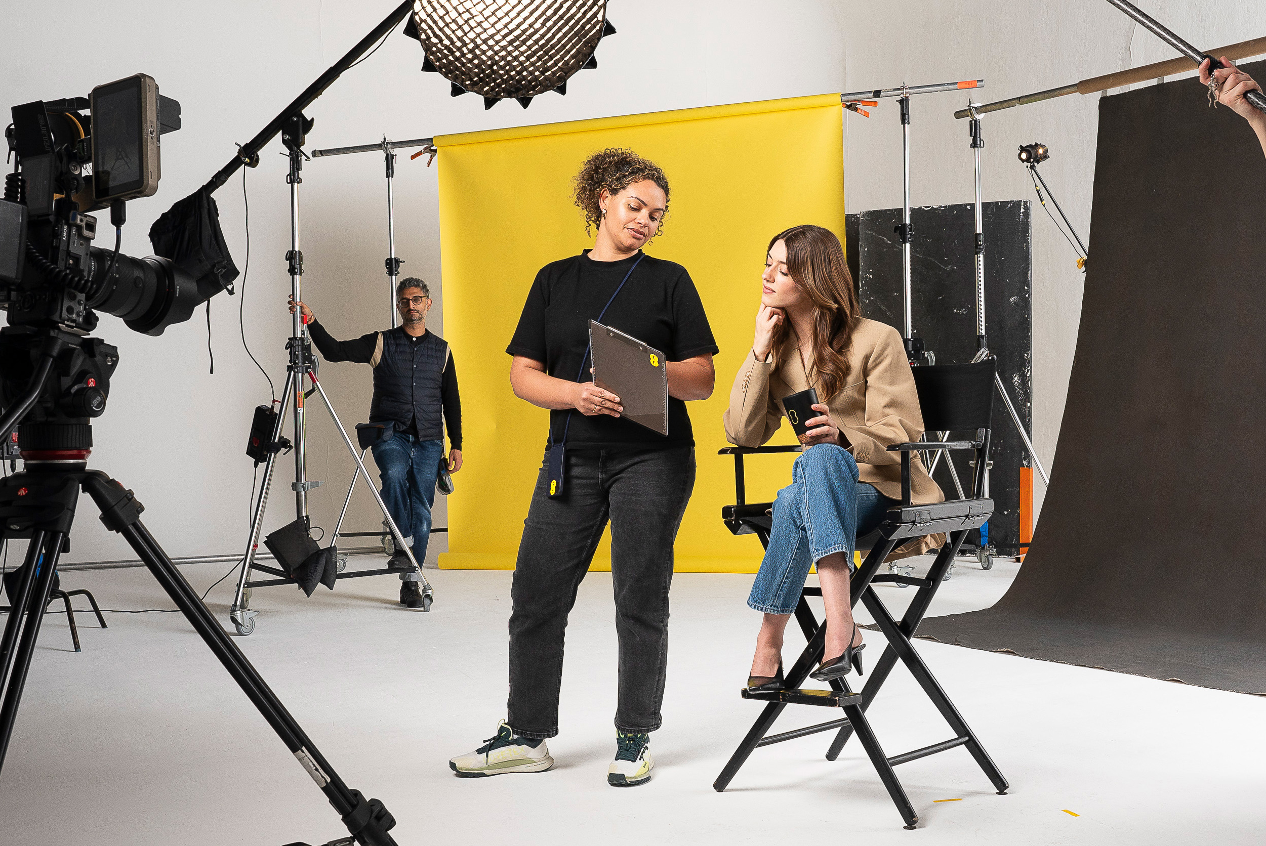 Daisy Edgar-Jones sitting on a director's seat in a studio