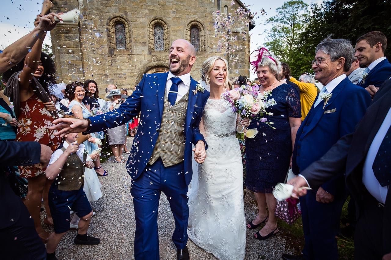 Nigel Cann and wife Mary outside a church on their wedding day as guests throw confetti