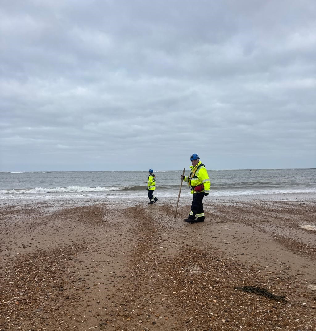 People wearing hi-vis jackets on a shore line