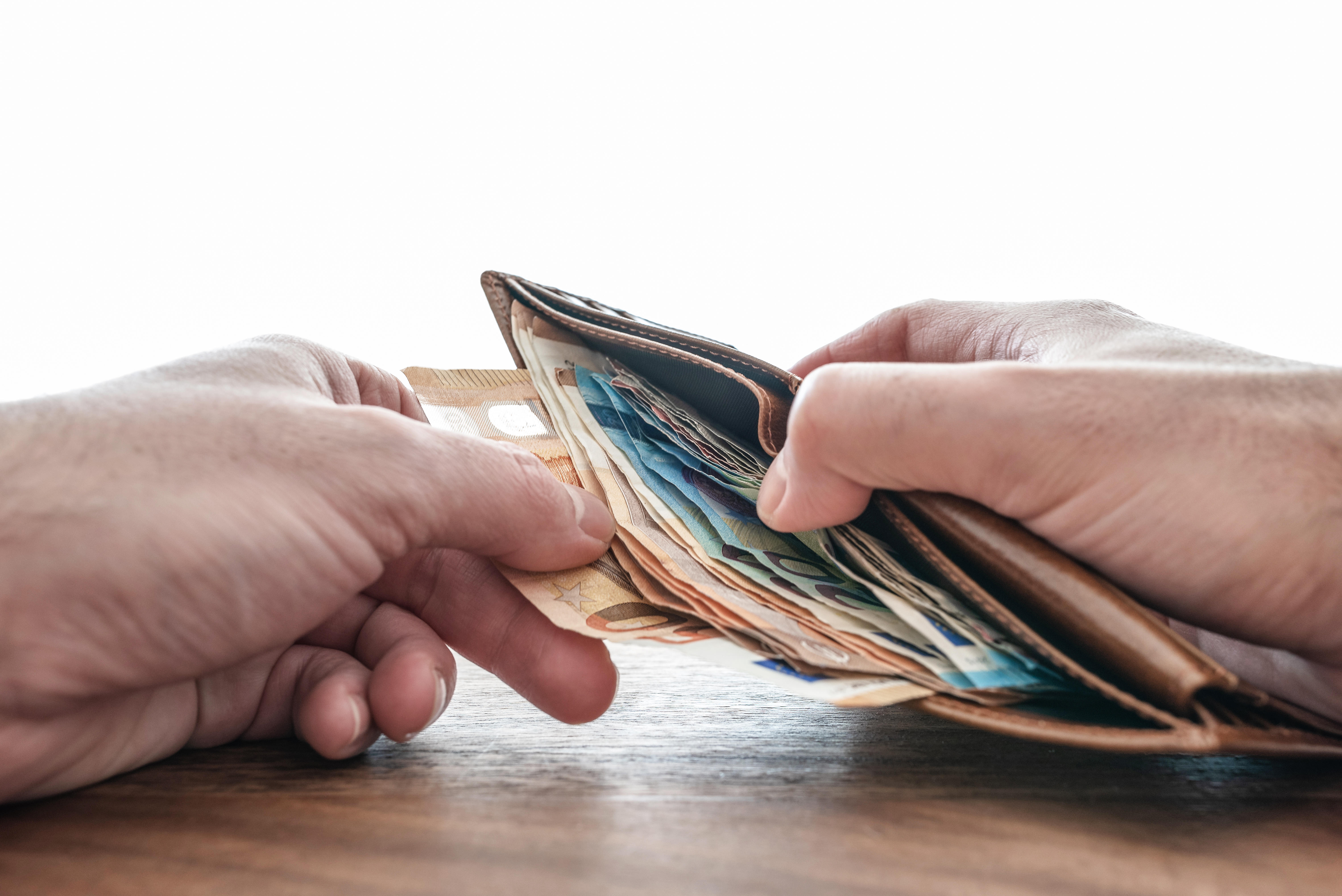 Hands taking paper money out of a wallet