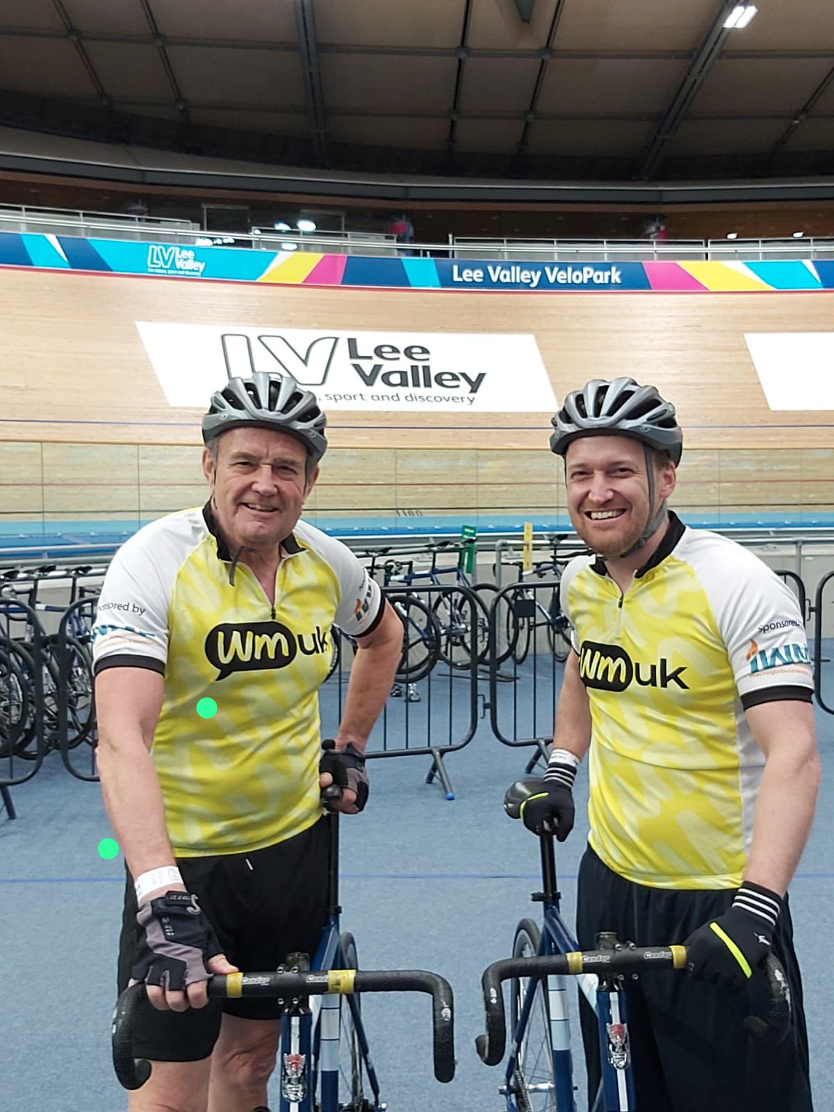 Bob standing beside his son, both wearing cycling gear 