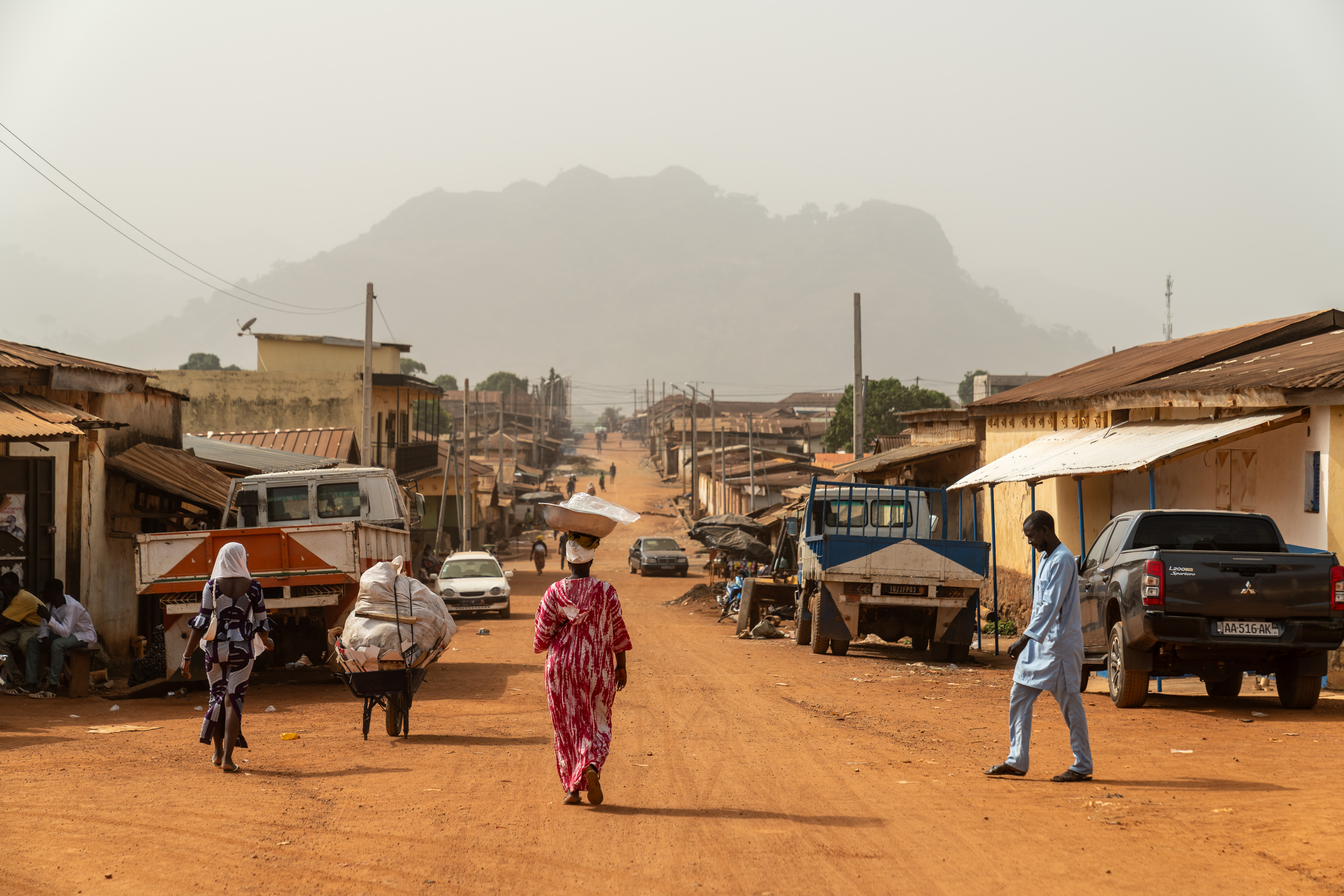 Pedestrians walk past the Yeyasso warehouses in the centre of the city of Man, the Bafing-Tonpki region, Ivory Coast in February 2025.