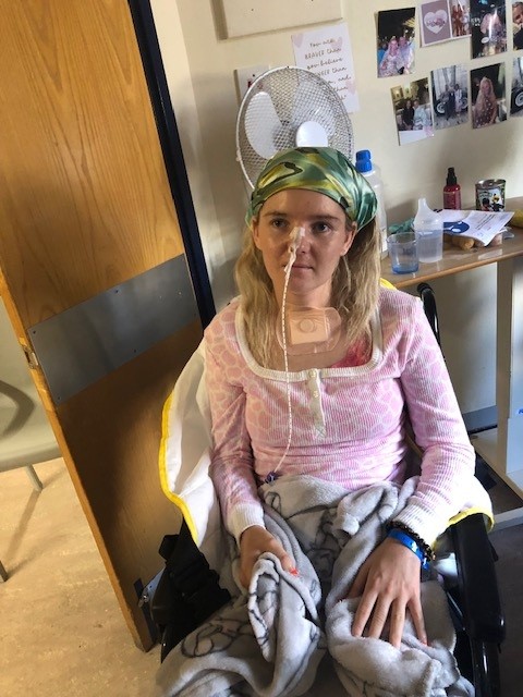 Summer Clarke seated in a wheelchair, wearing a nasal tube