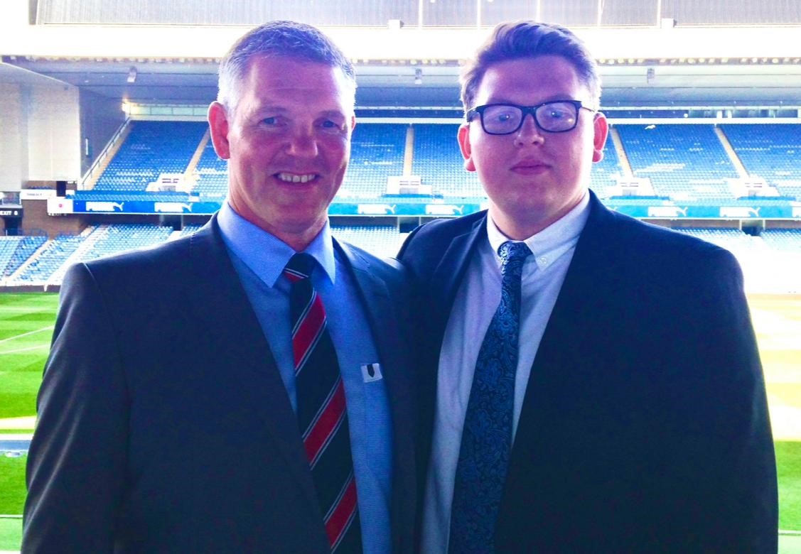 Craig and Chris Murray wearing suits at a sports ground