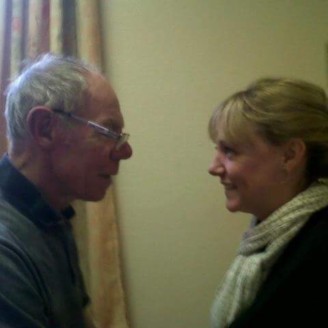 Helen and her father standing in front of each other and smiling 