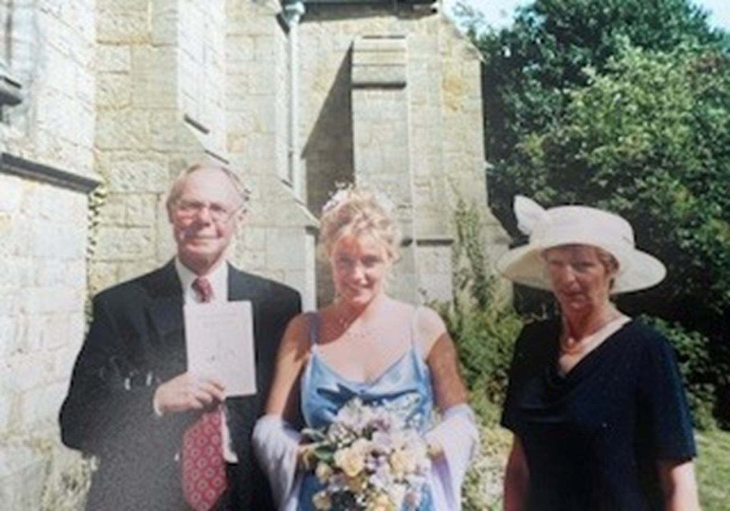 Helen standing in between her parents outside a church