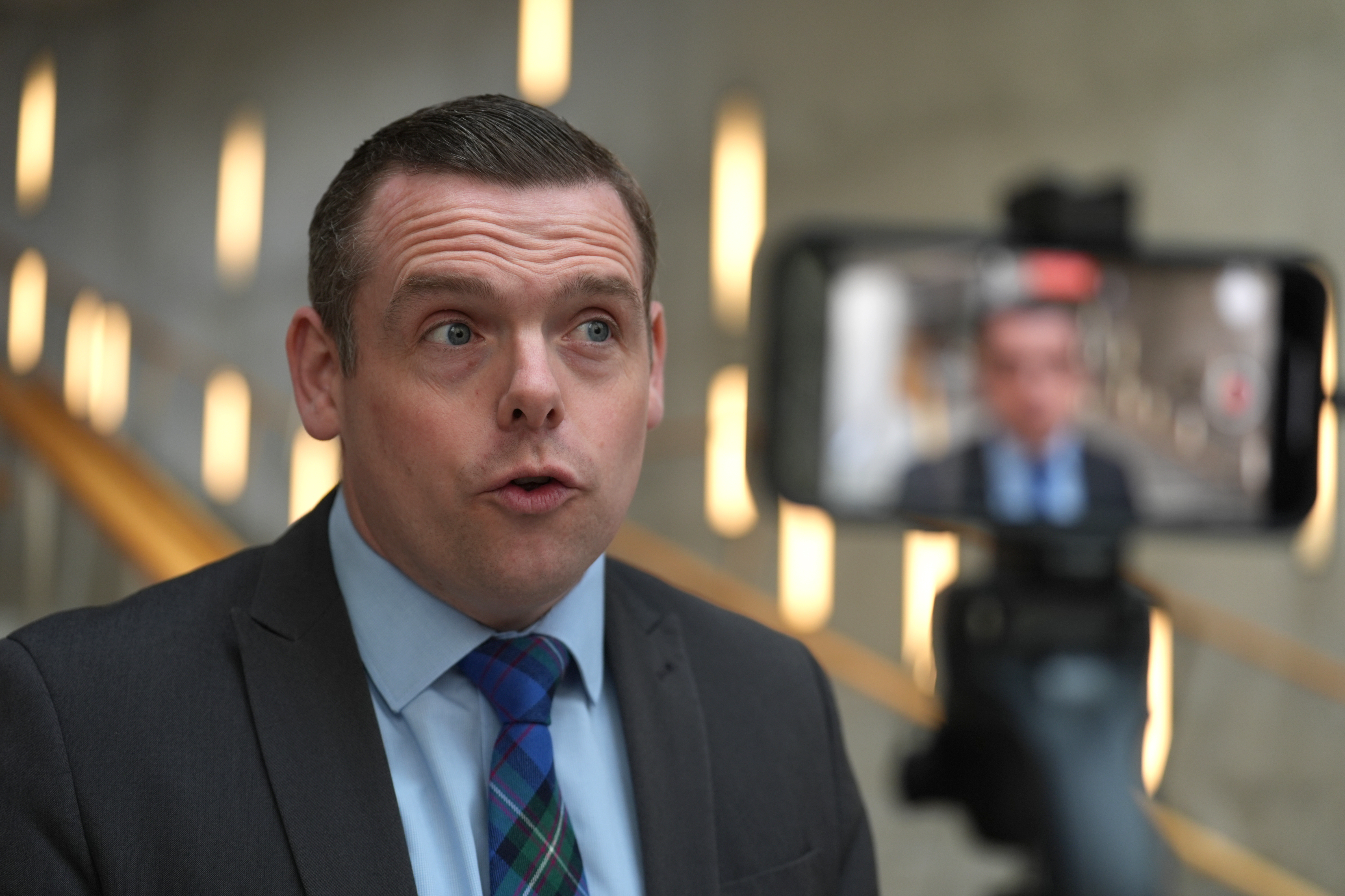 Douglas Ross speaking while being interviewed, with a camera phone positioned in front of him