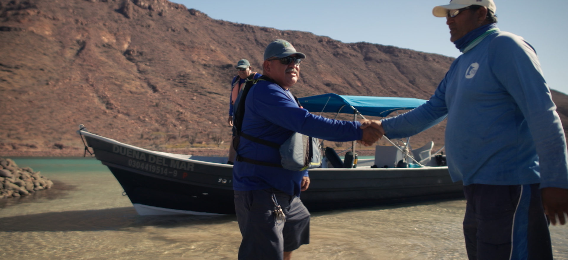  Captain Jose Luis Cesena Calderon shakes hands near a boat