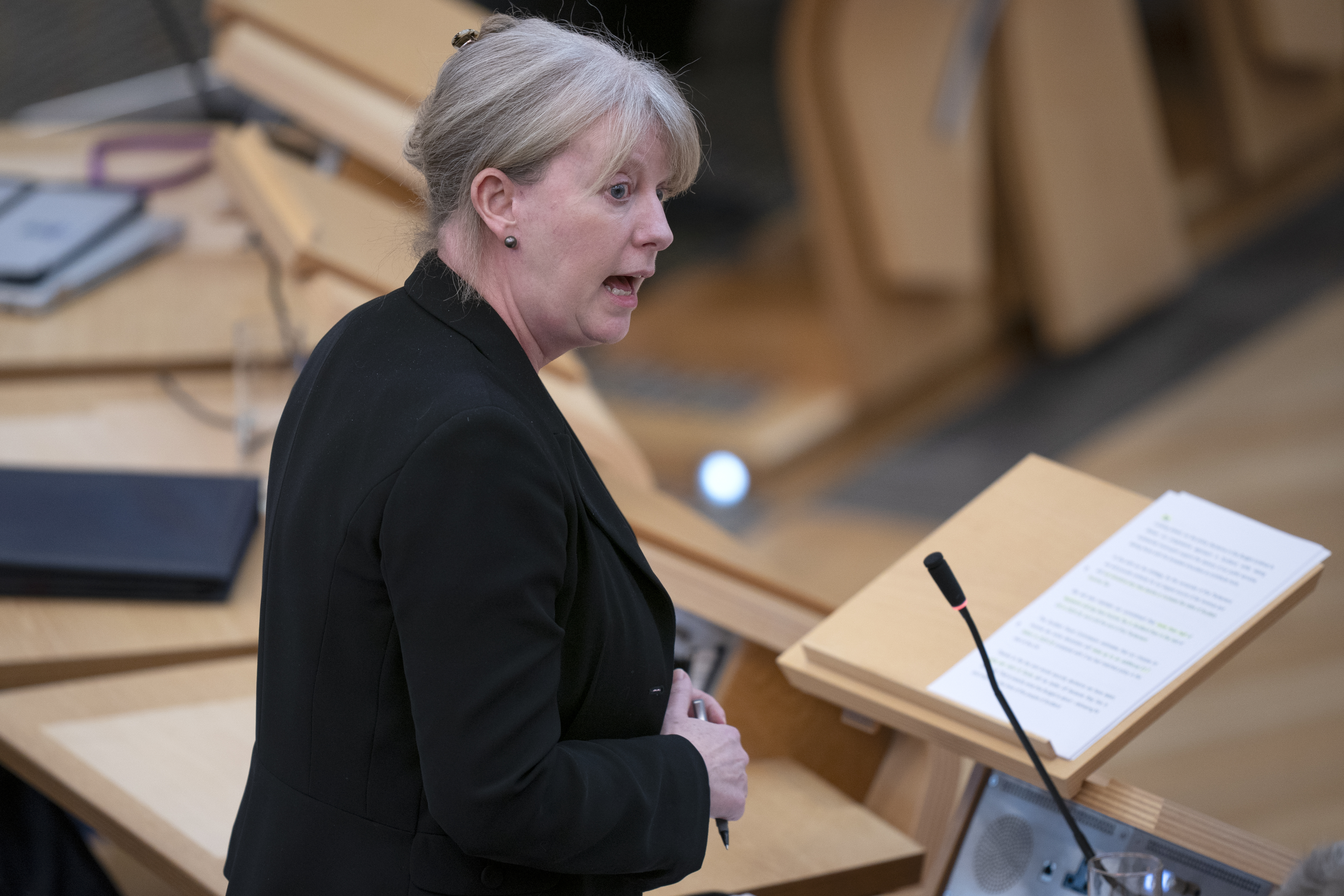 Shona Robison standing while speaking in Parliament