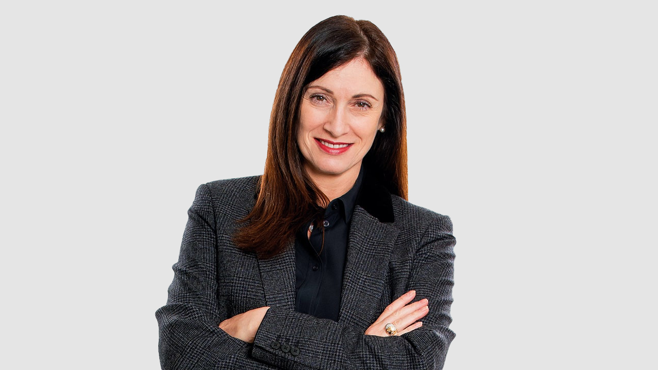 Cindy Rose smiling, while standing her arms folded