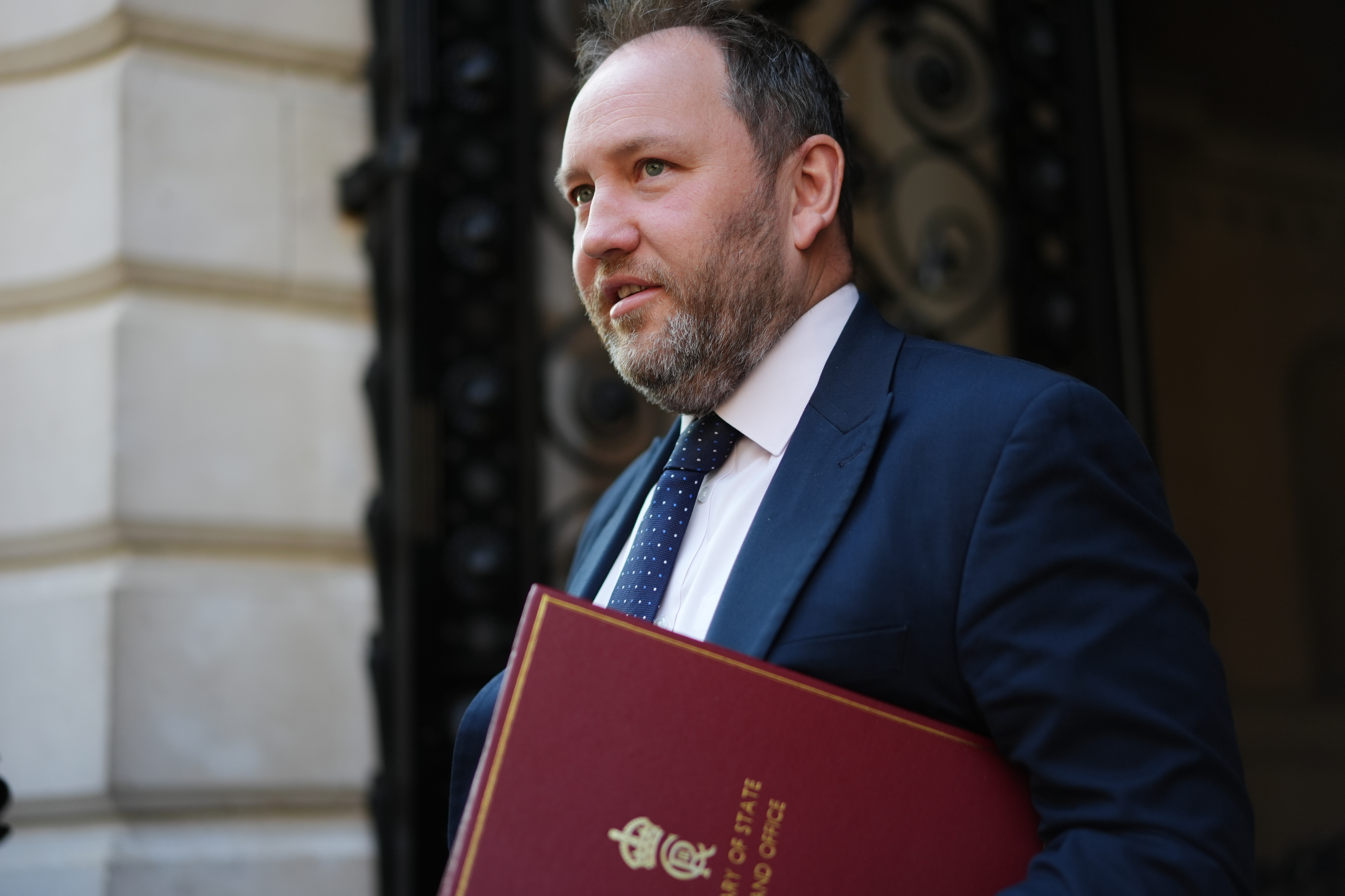 Ian Murray walking outside with his red ministerial folder under his arm