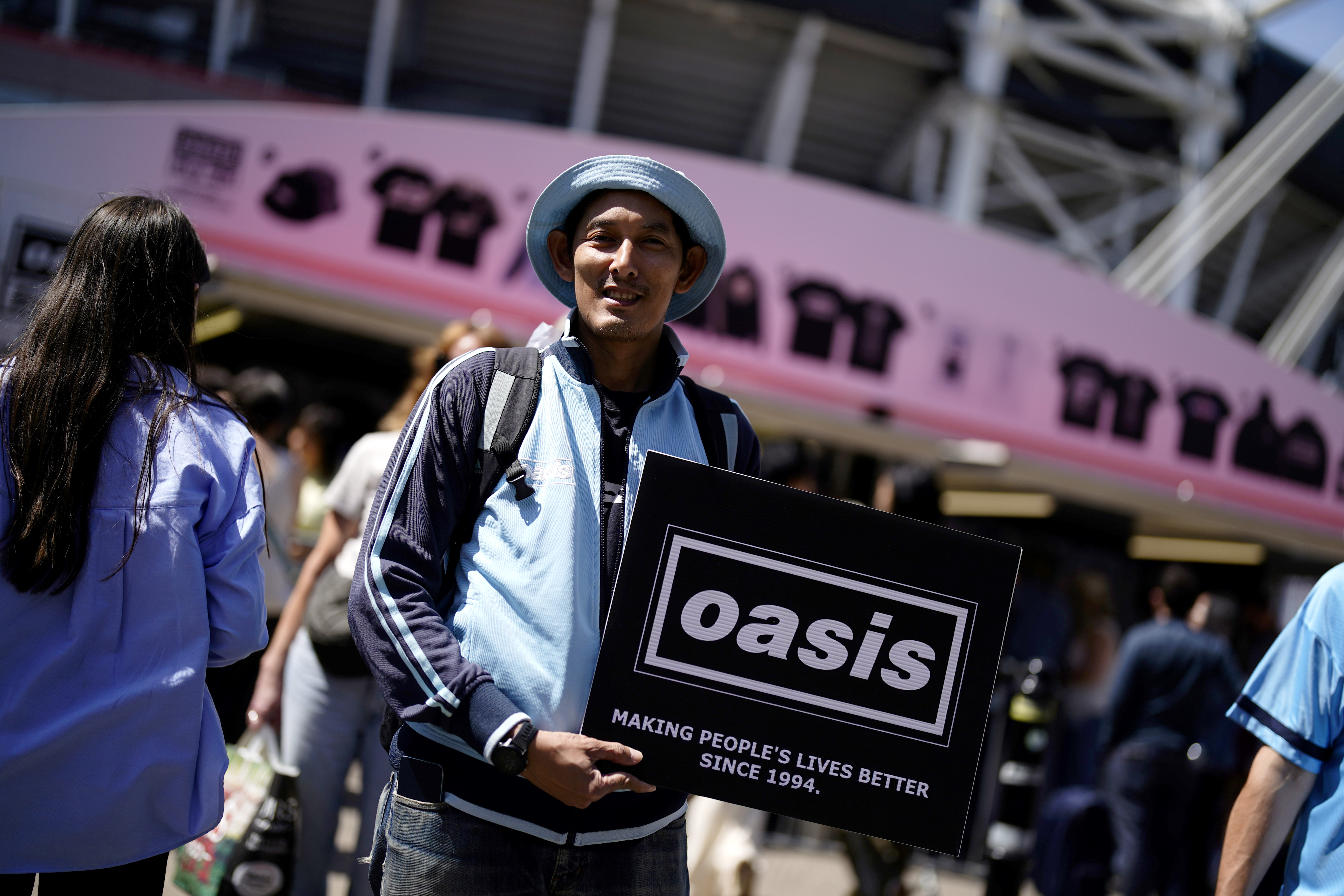 An Oasis fan holds up his sign outside the Principality Stadium