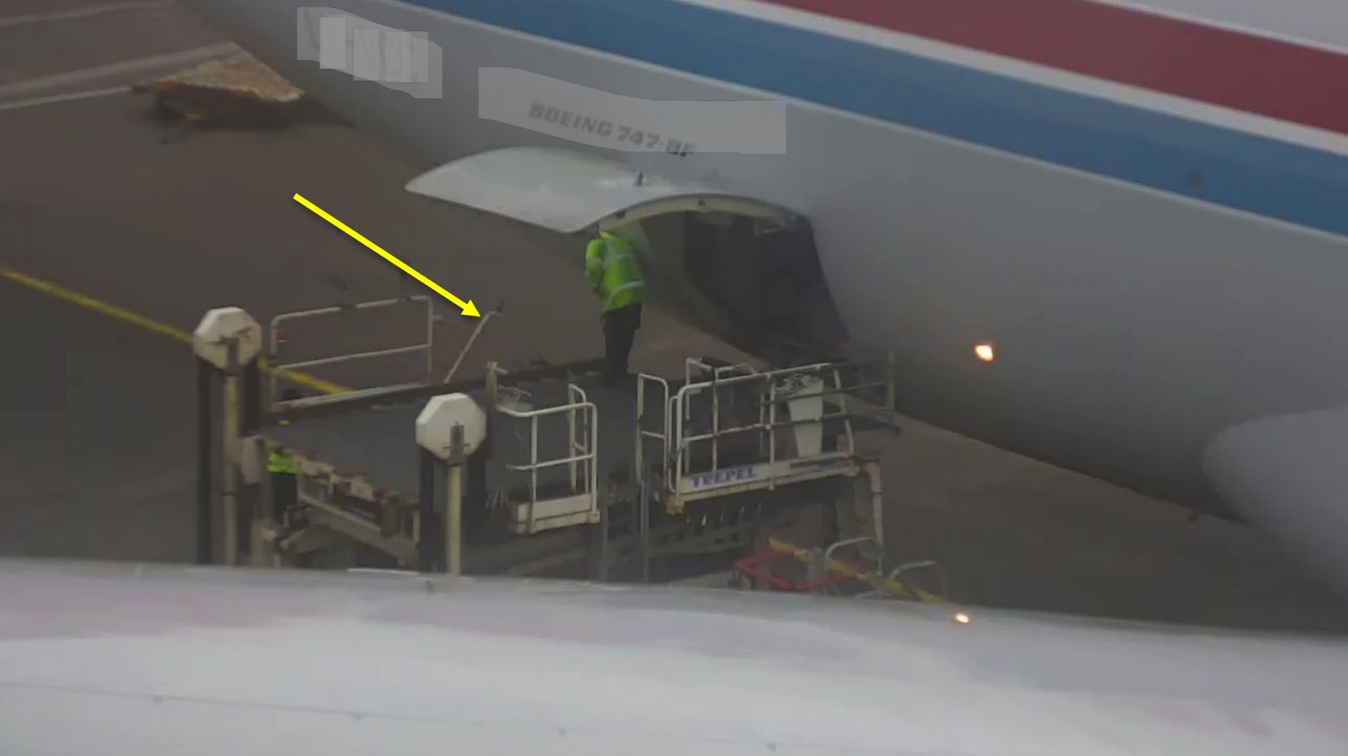 Platform loader next to plane, with a yellow arrow showing the broken guardrail