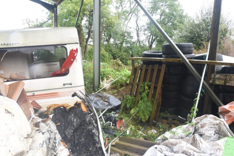 A caravan surrounded by rubbish