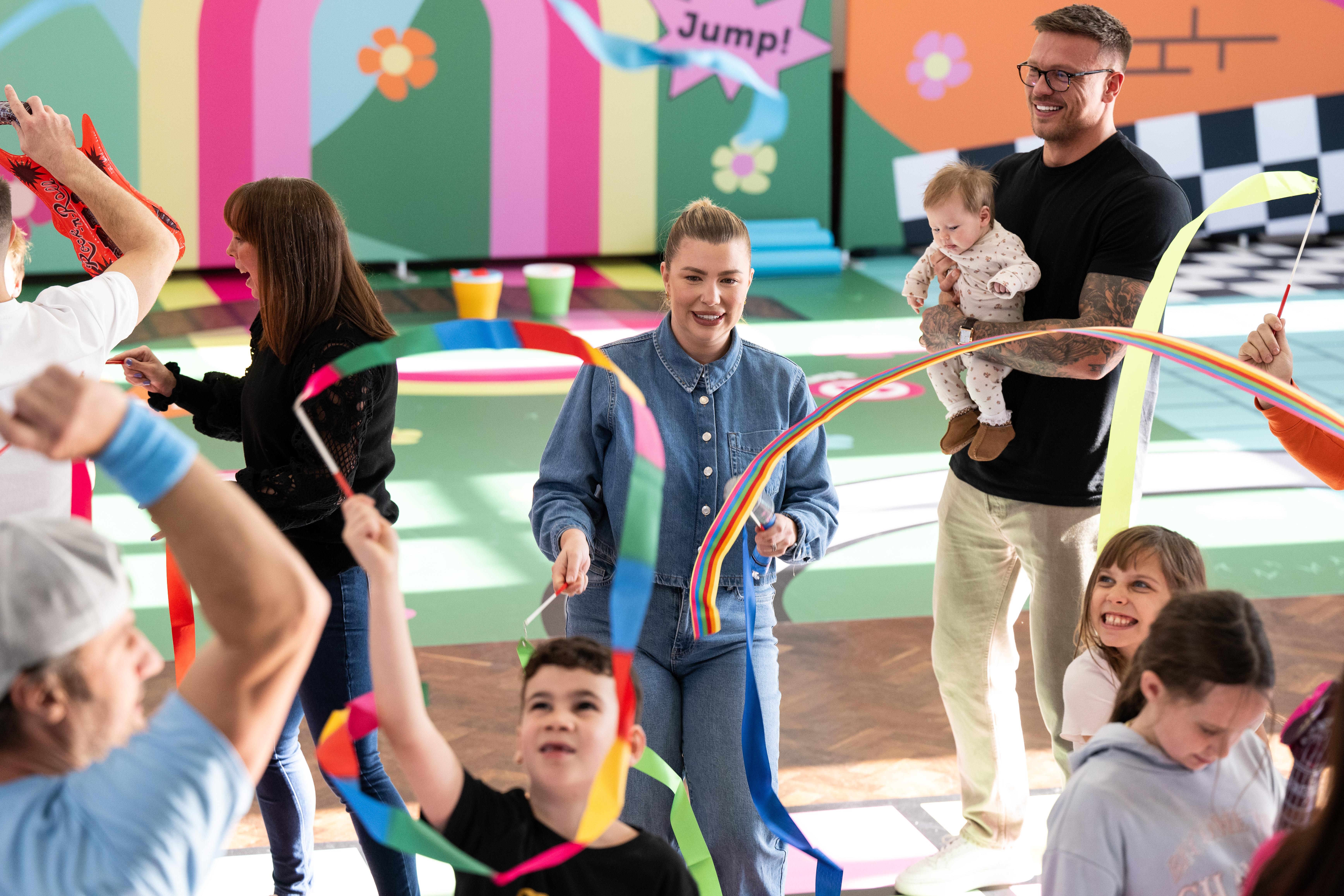 Alex Bowen holds baby Siena as wife Olivia plays with children at the Let's Move launch (DCMS/PA)