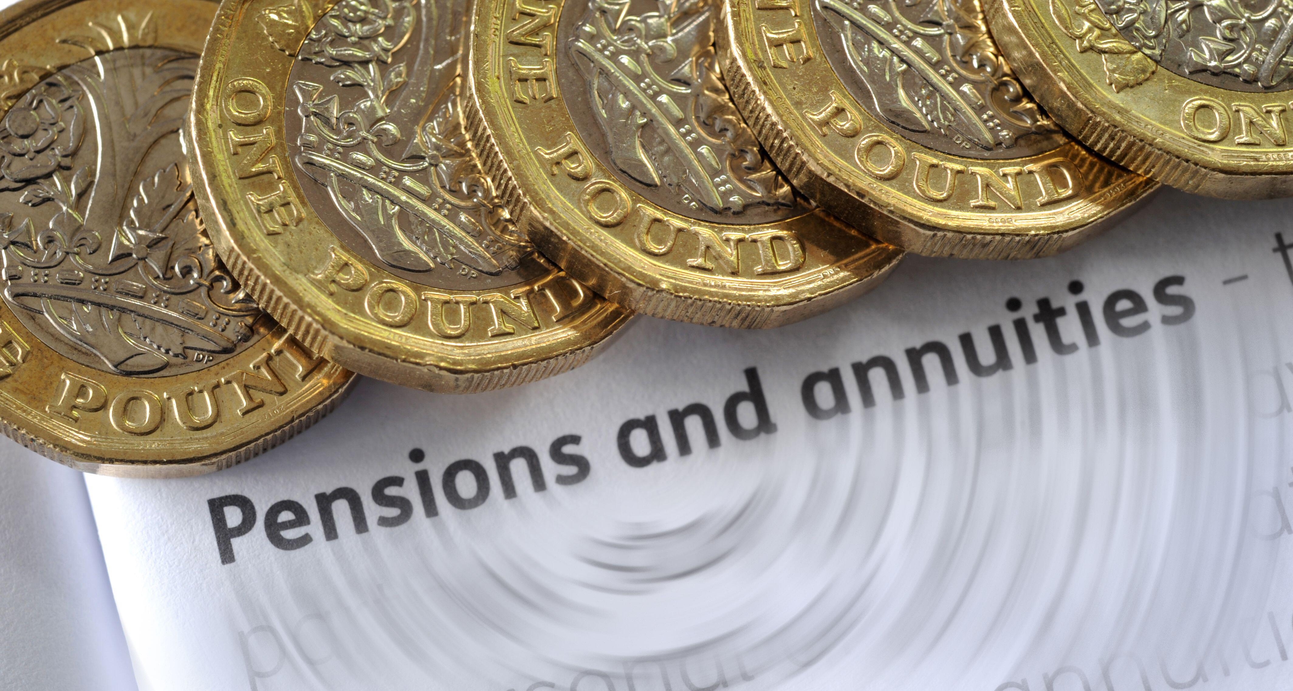 Several £1 coins on a leaflet about pensions and annuities