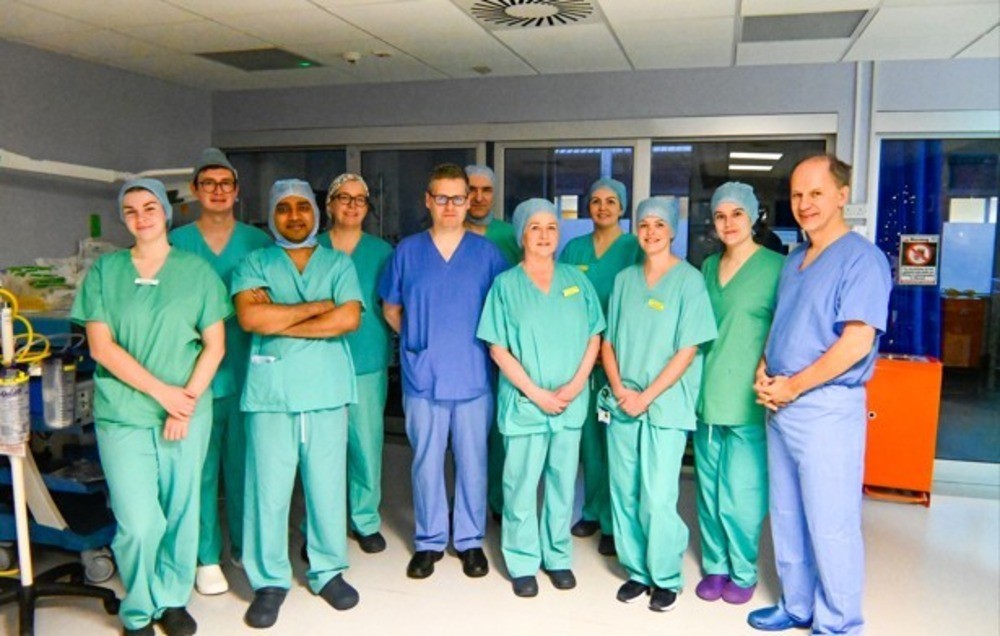 A group of medical staff posing for a photo, wearing medical scrubs
