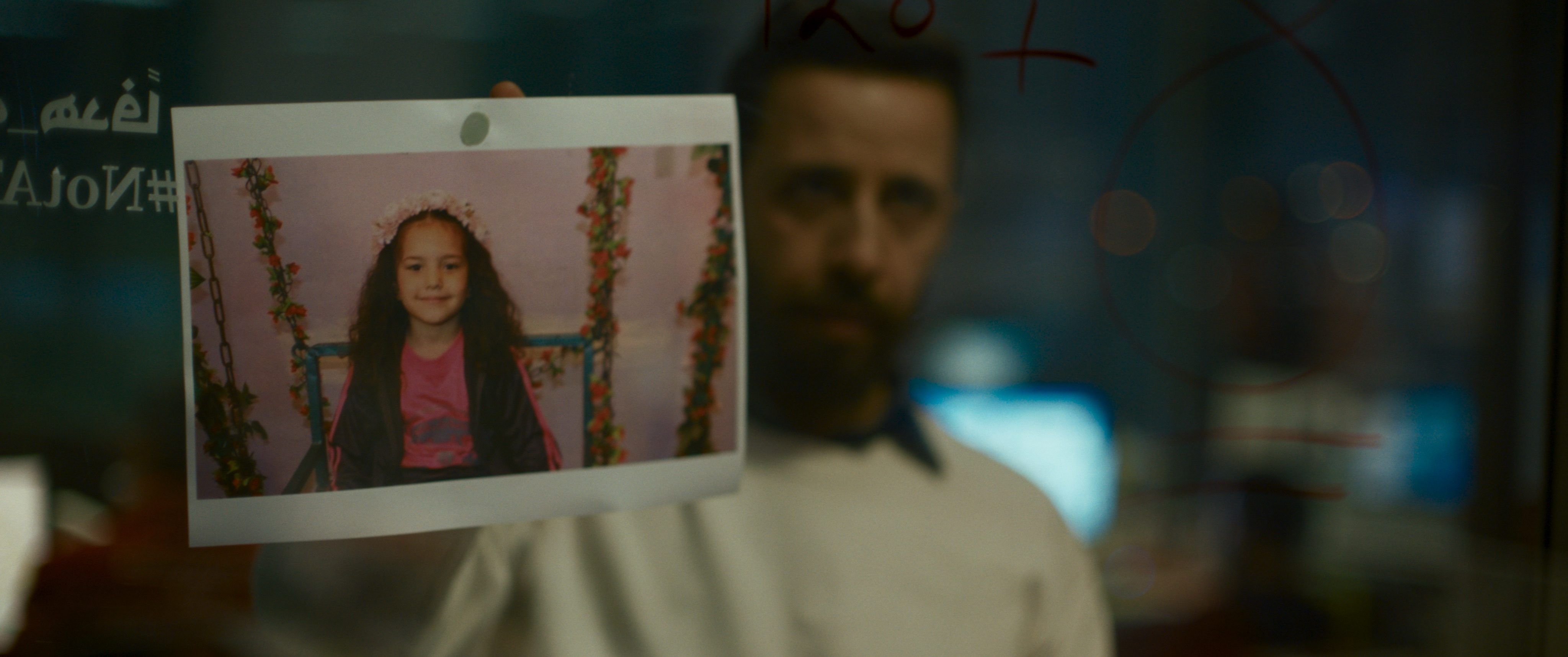 A man stands behind a picture of a young girl