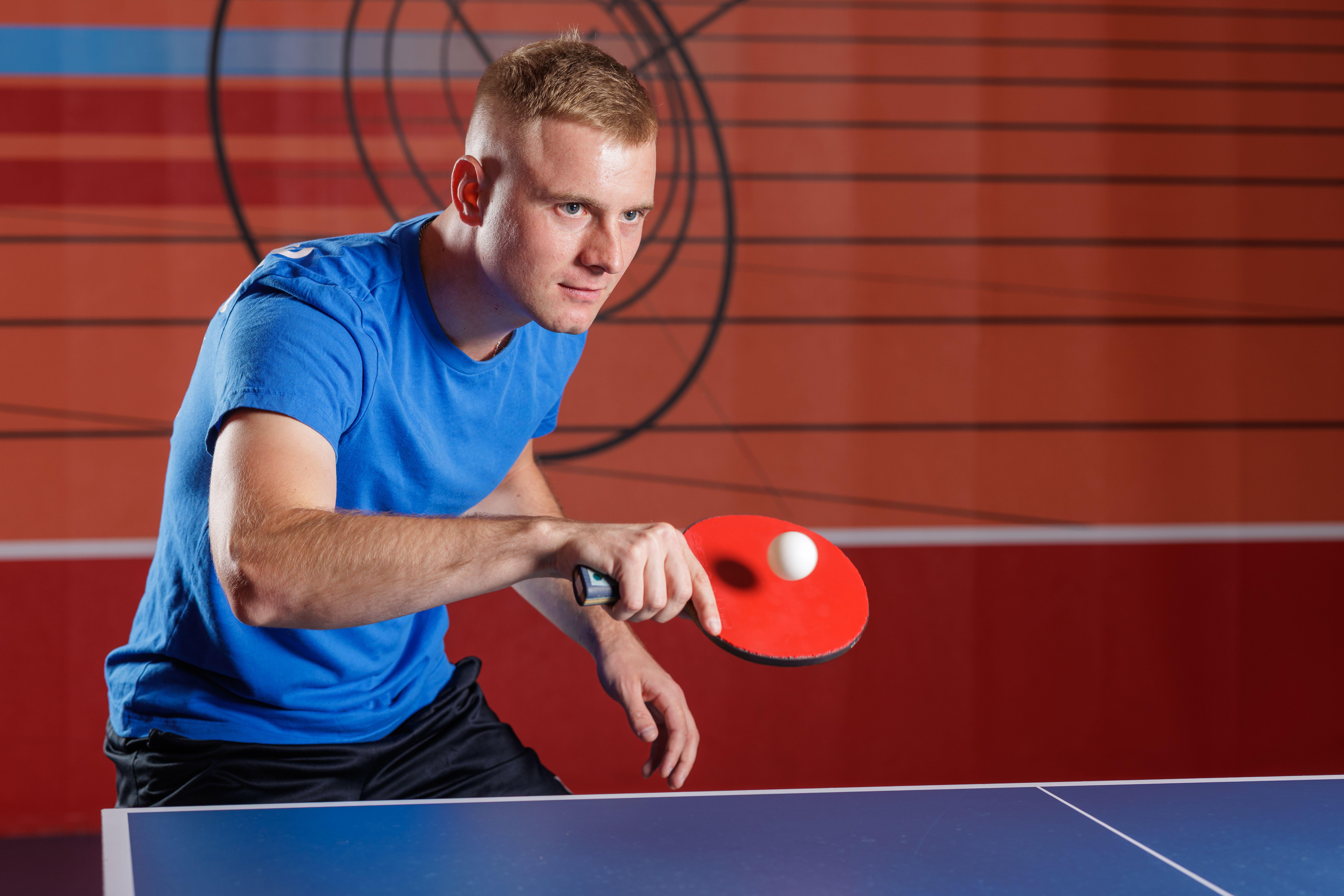  Male athlete playing table tennis in a club setting 