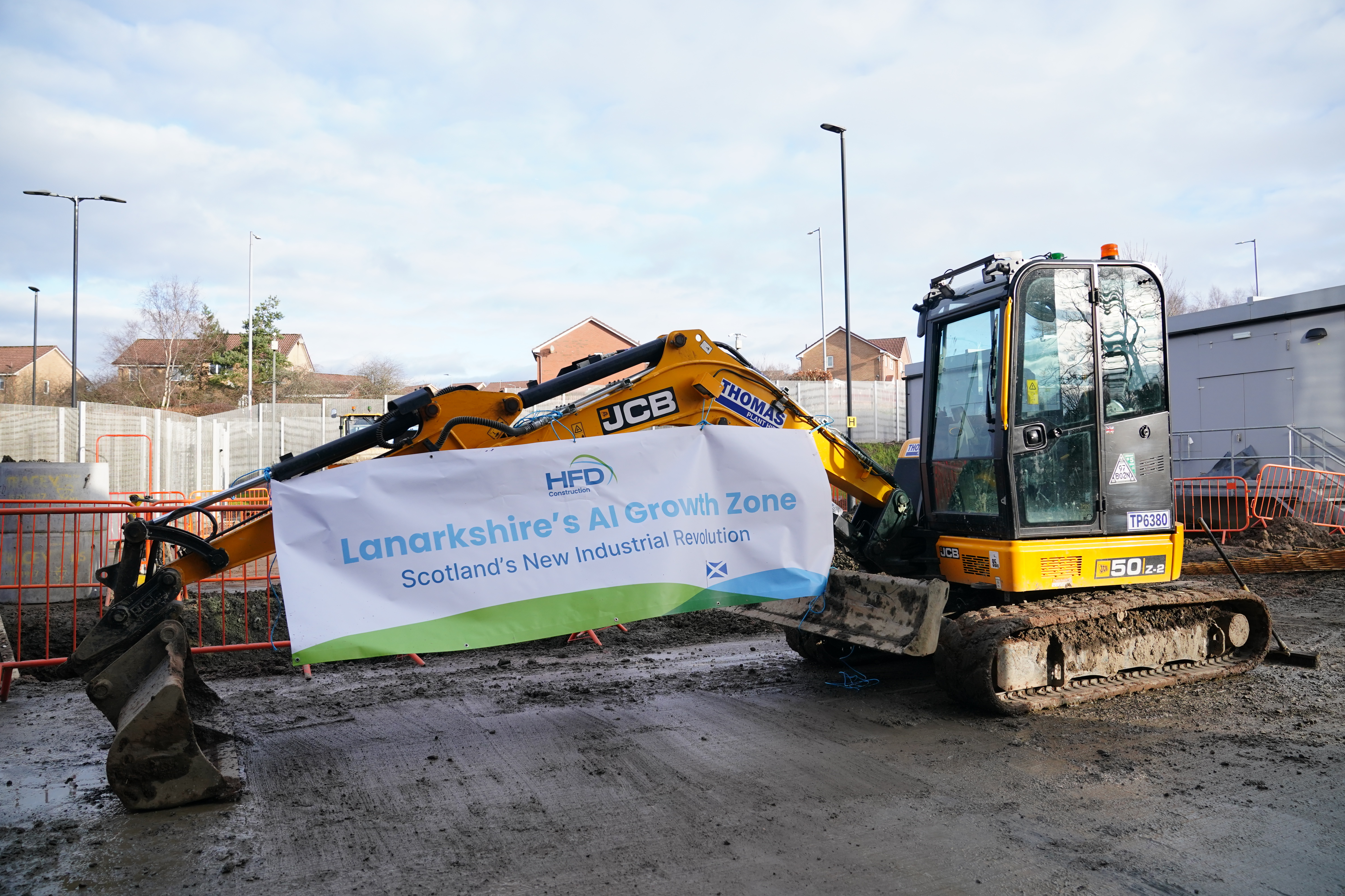 A digger on a construction site, with a sign that reads 'Lanarkshire AI Growth Zone'