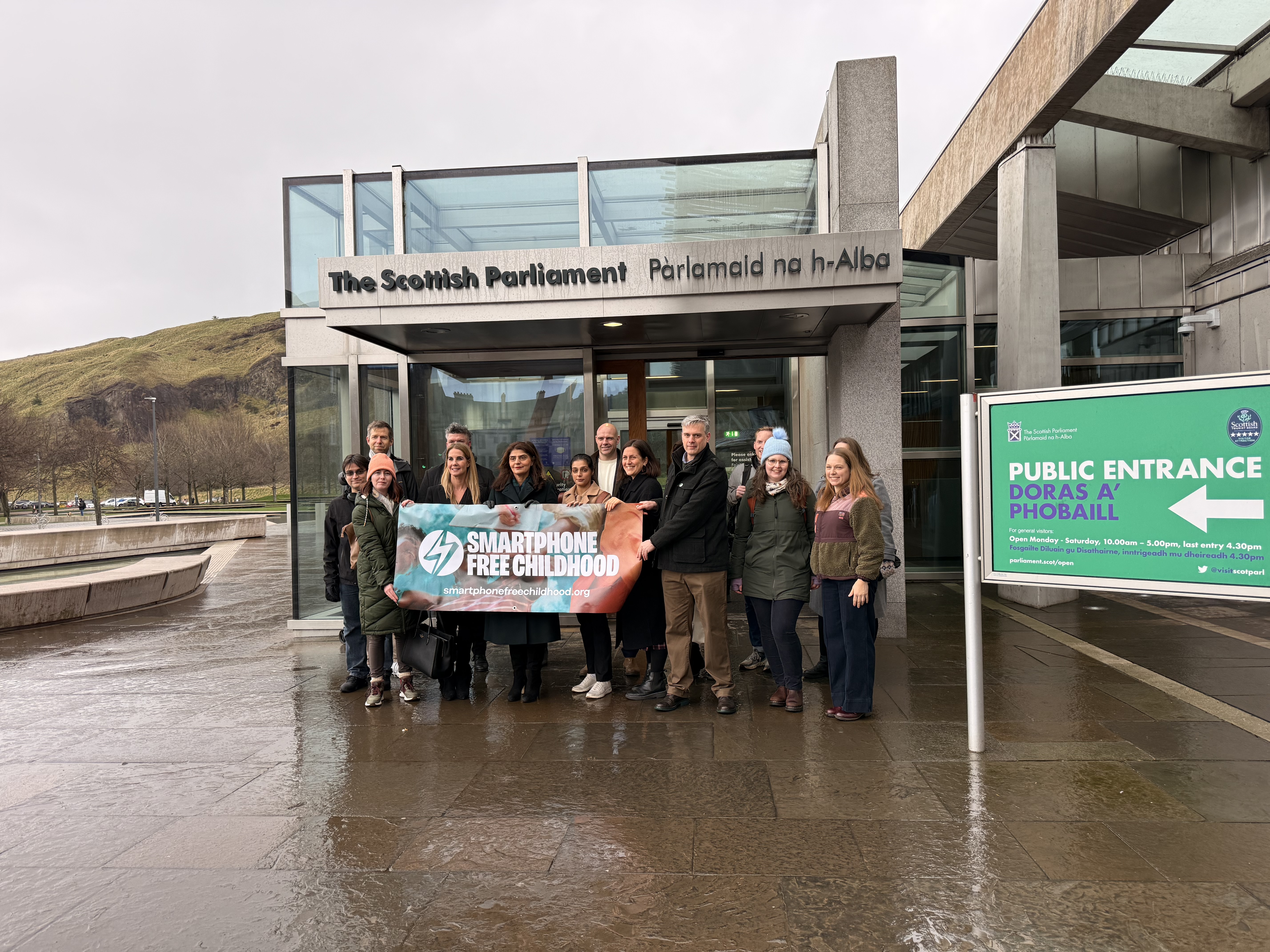 A group of people hold a banner saying 'Smartphone Free Childhood' outside the Scottish Parliament