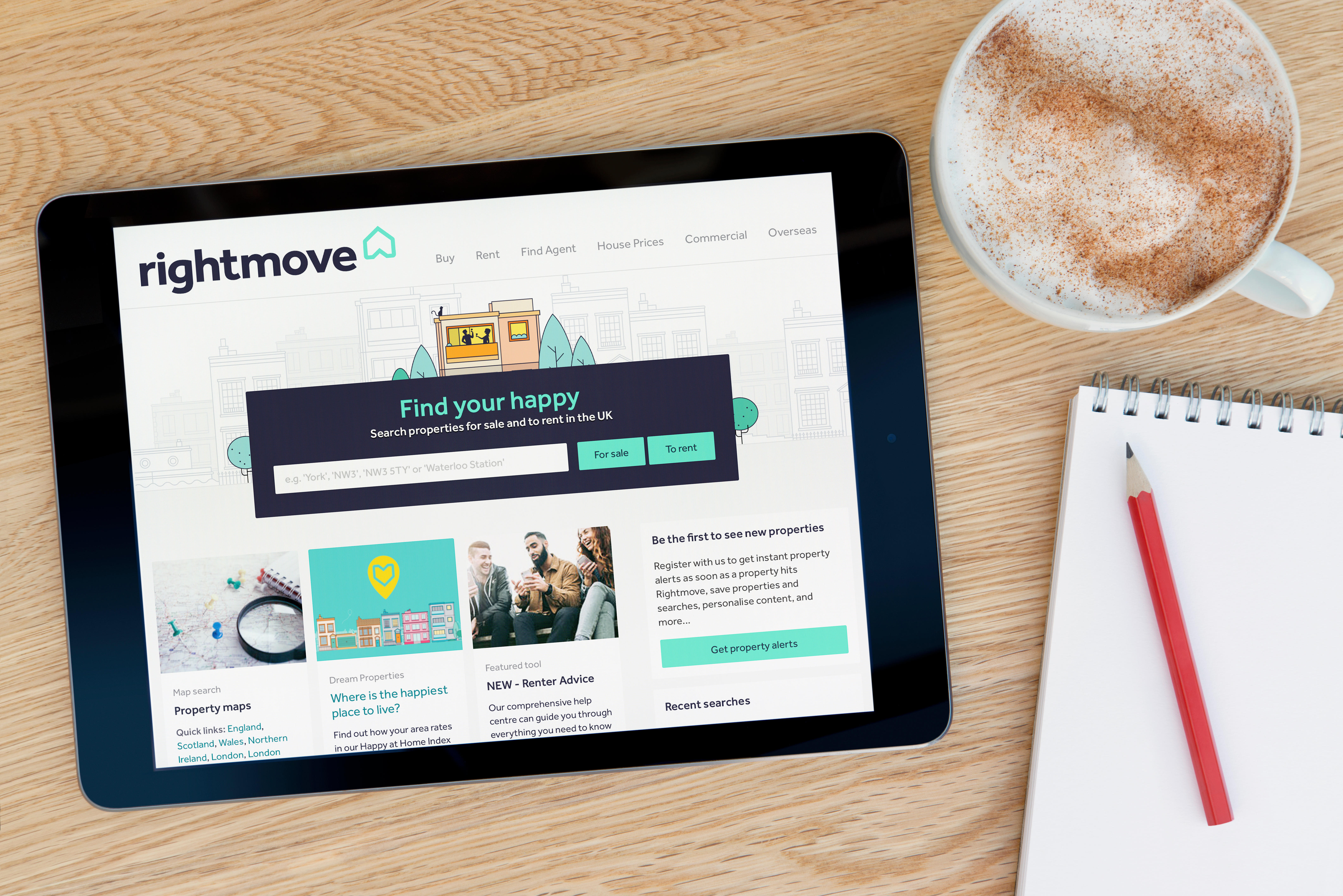 Rightmove displayed on a tablet, with a notepad and pencil and cup of coffee beside it