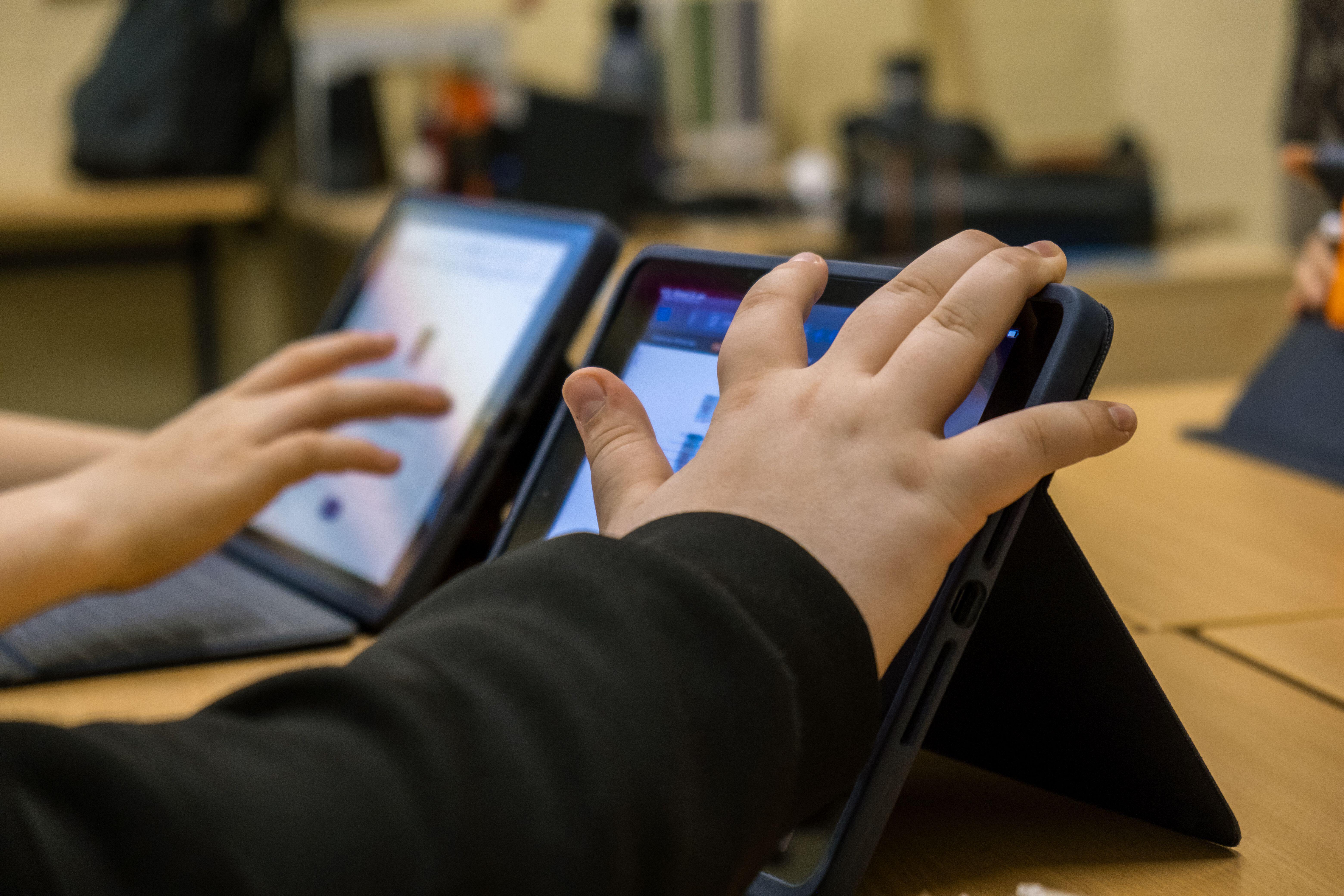 A child's hand over a laptop screen