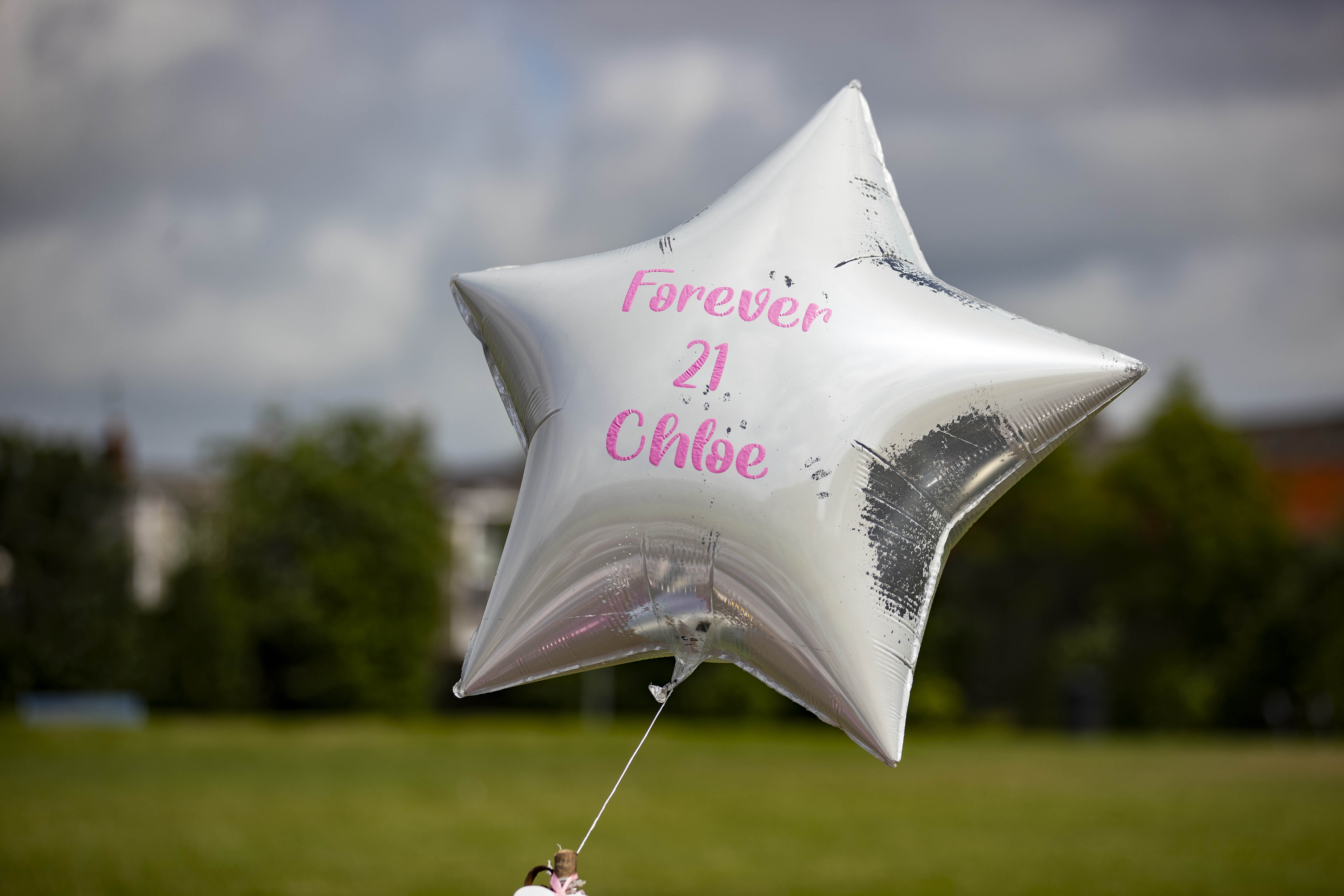 A star-shaped balloon flying in an open area, with the message 'Forever 21, Chloe' on it