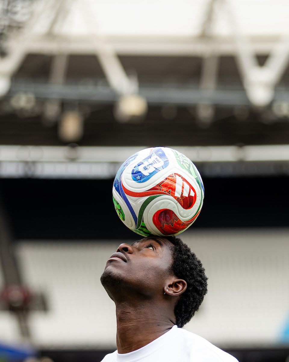 Damson Idris balancing a Soccer Aid football on his head