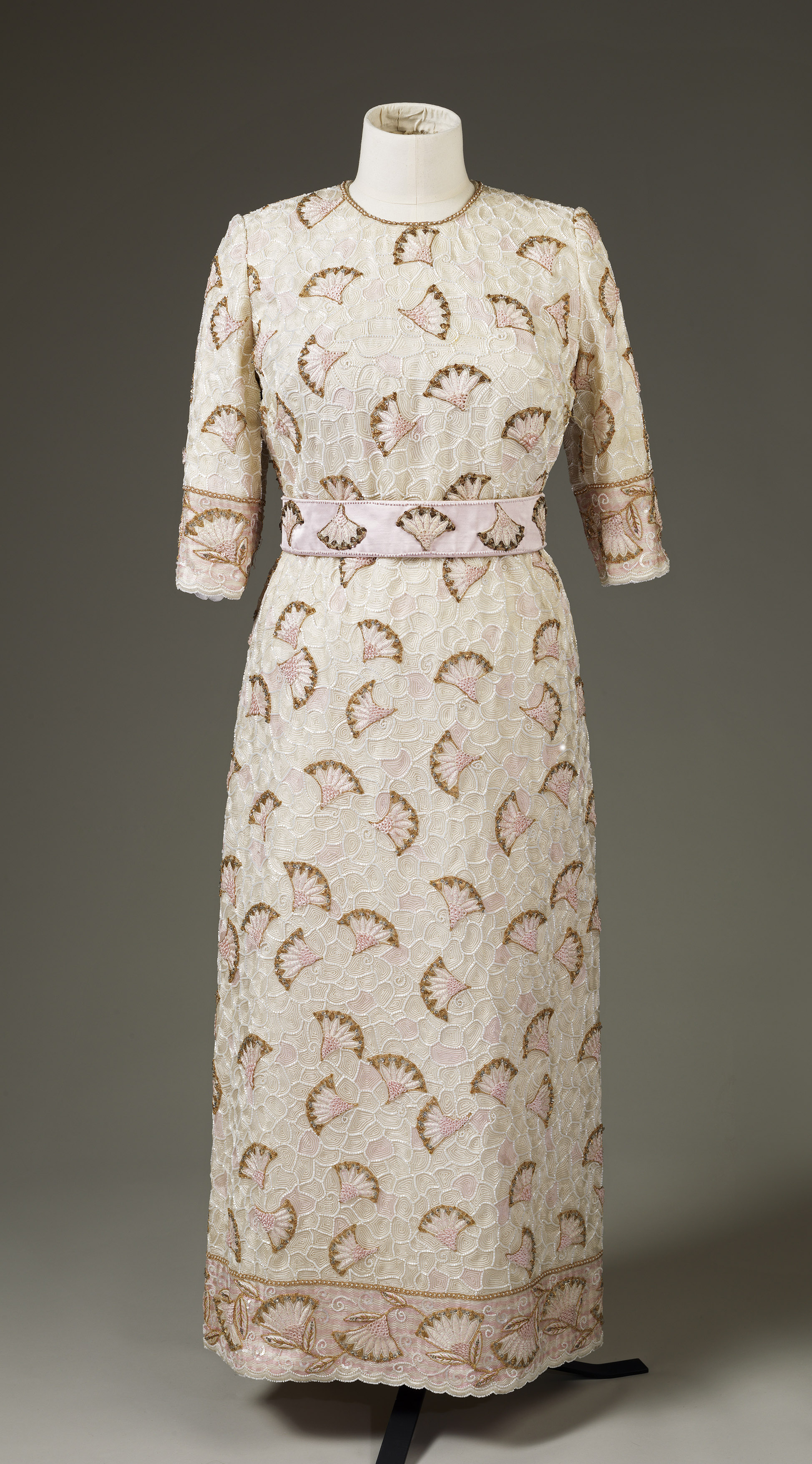 An evening dress featuring white, pink, gold and cream beads and sequins, embroidered with gold thread