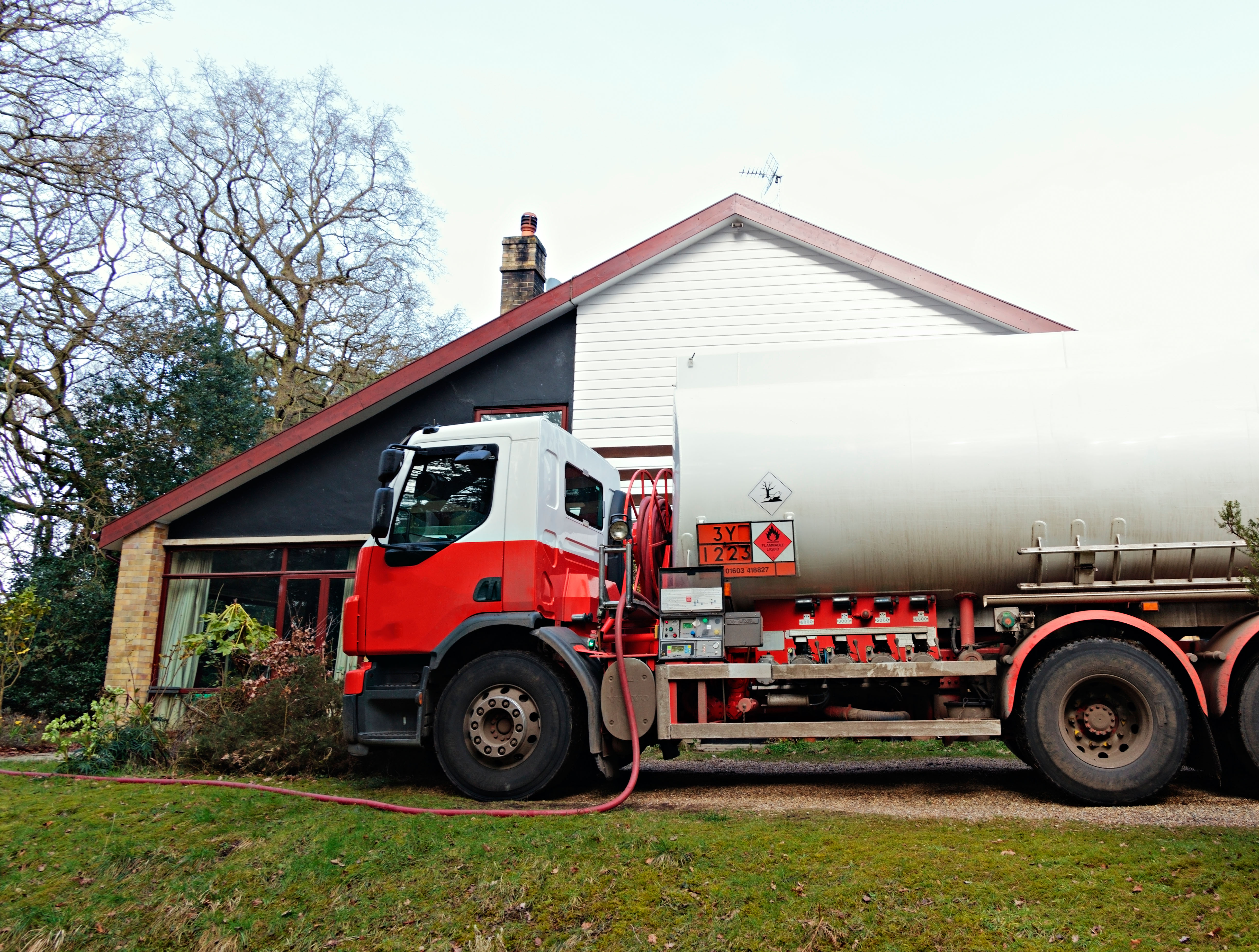 A fuel tanker making a delivery of domestic heating oil to a house