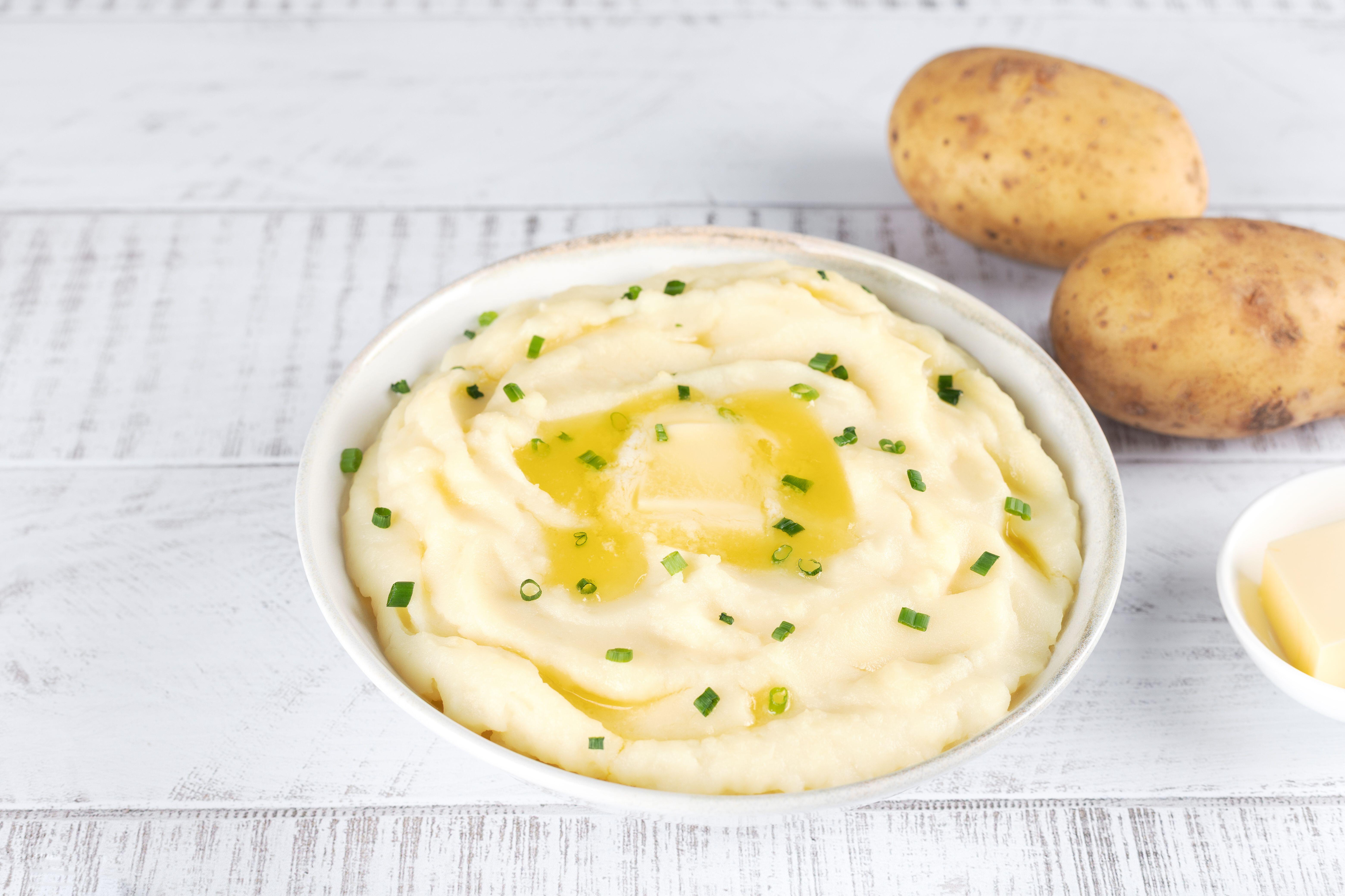 Bowl of Irish champ which consists of creamy mashed potatoes mixed with chopped scallions (spring onions), butter, and milk