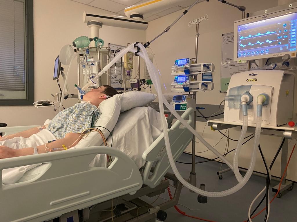 Ross Simpson hooked up to medical equipment while in a hospital bed