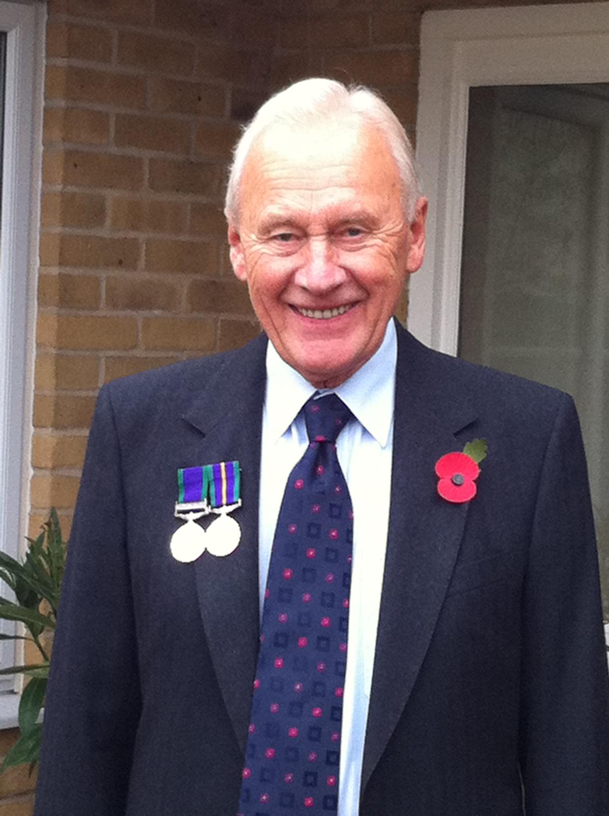 John Dockerty dressed in a suit poses for a photo