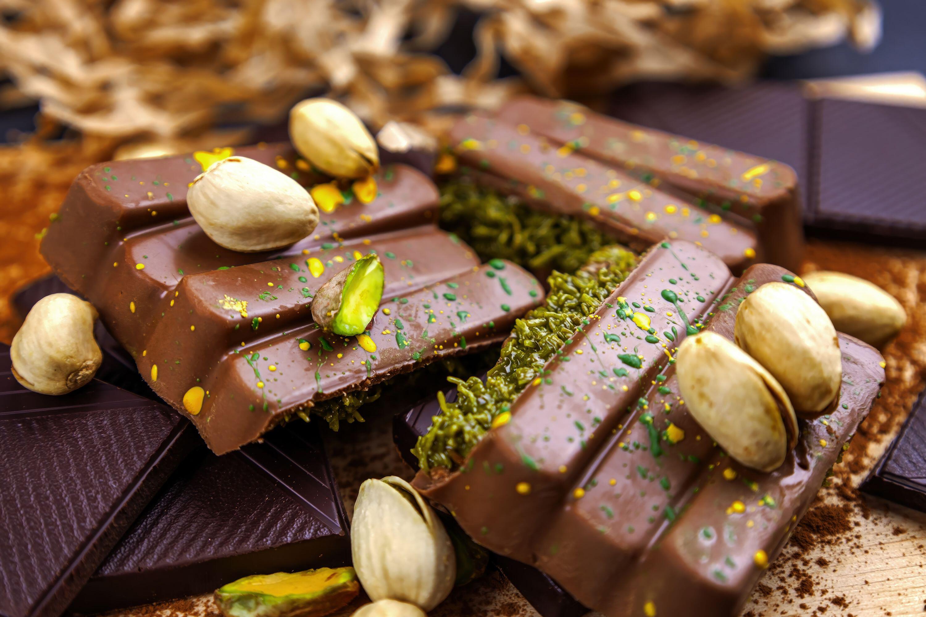 Dubai chocolate bar with green kadayif and pistachio spread with pistachio nuts close up