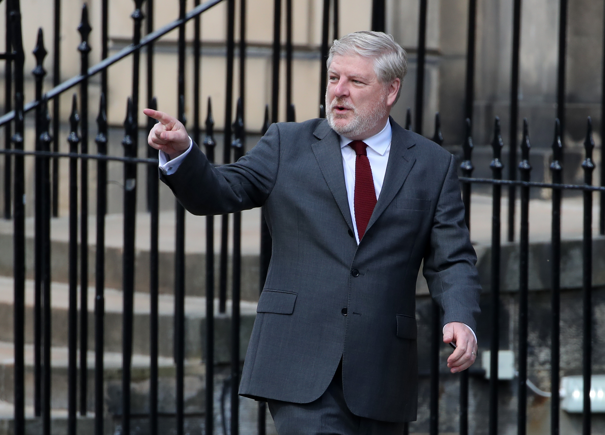 Angus Robertson pointing to his right while walking outside