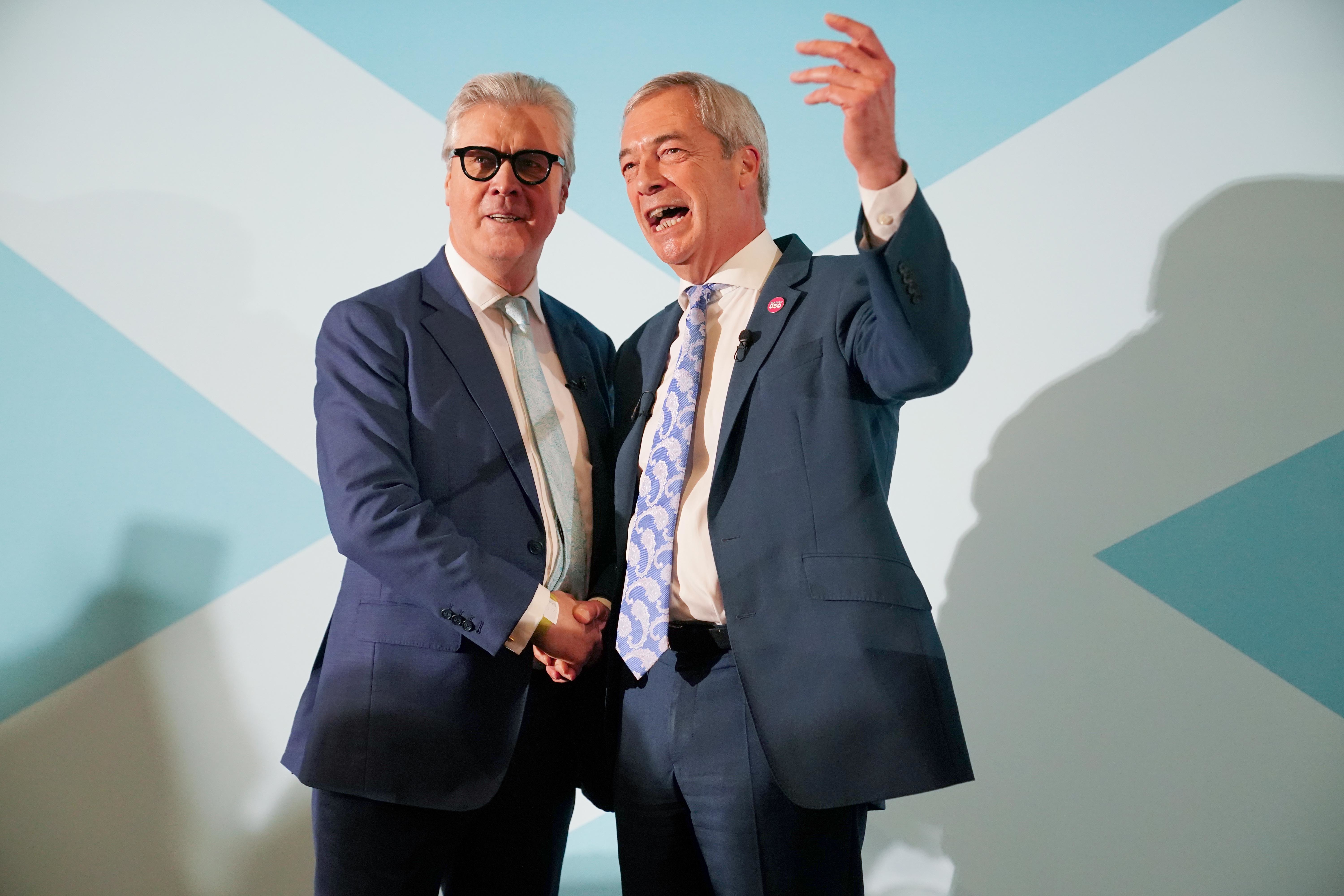 Nigel Farage (right) shaking hands with Lord Offord in front of a Saltire