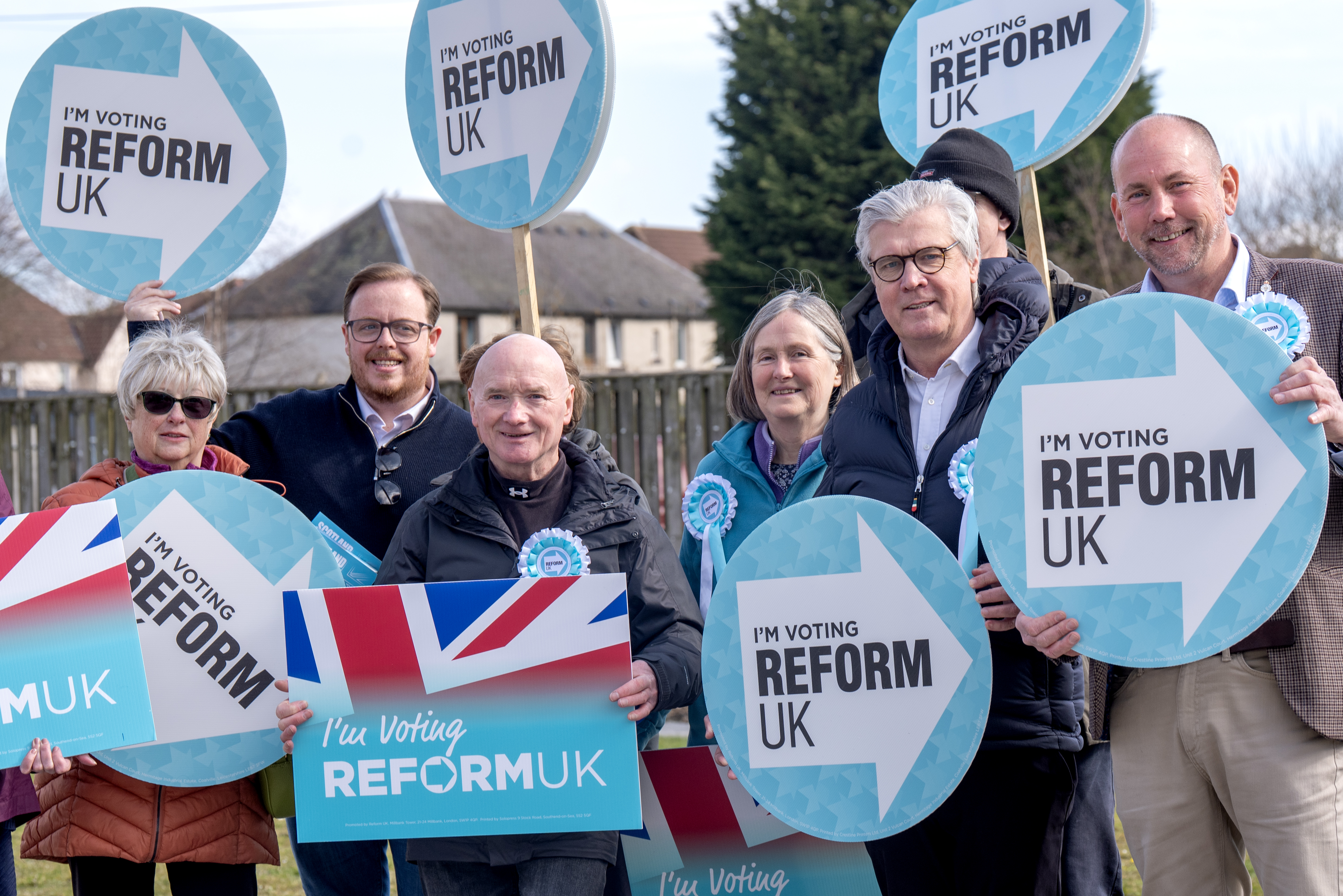 Lord Offord (second right) holding Reform UK placards with fellow party activists