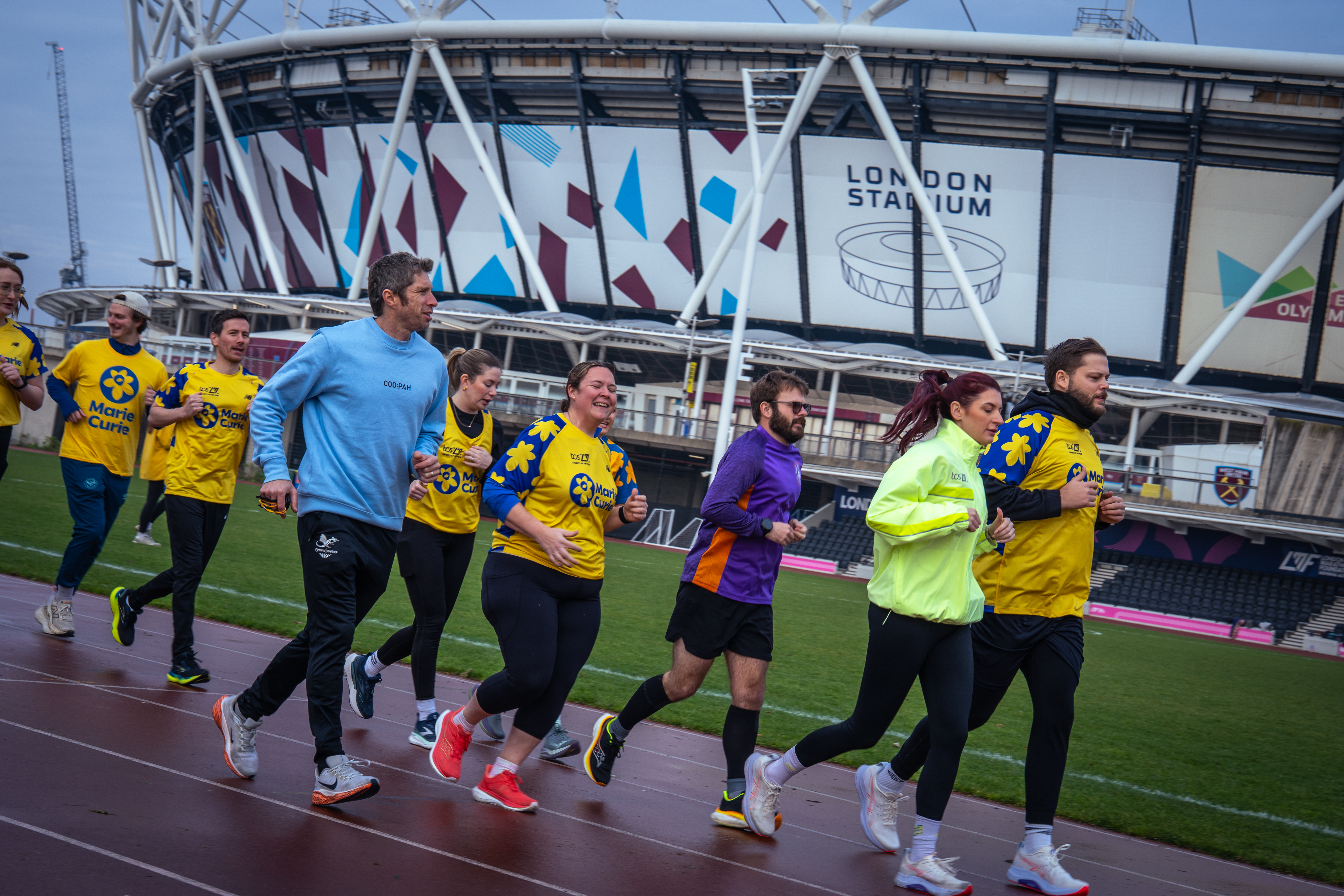 neil and Sadhbh Howarth at the front of a group of Marie Curie TCS London Marathon runners training on the track at the London Marathon Community Track in the Queen Elizabeth Olympic Park, in Stratford, east london