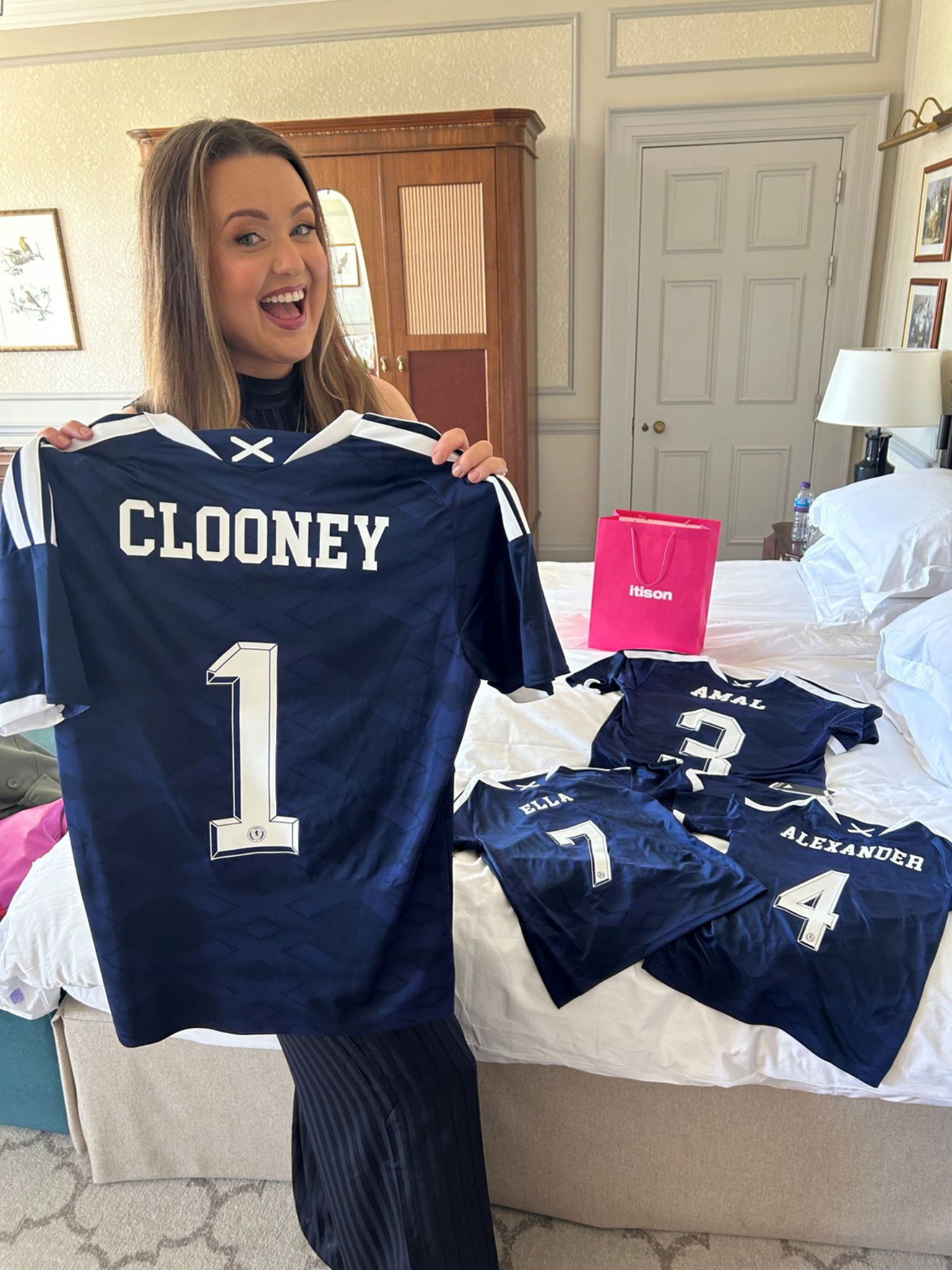 Prize draw winner Claire Phale holds up a Scotland kit with the name Clooney on the back, ahead of gifting it to Hollywood star George Clooney