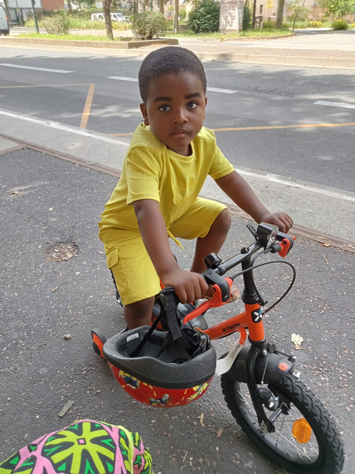 Laurys N'Djosse Adeyeye in a yellow T-shirt and shorts riding a bike