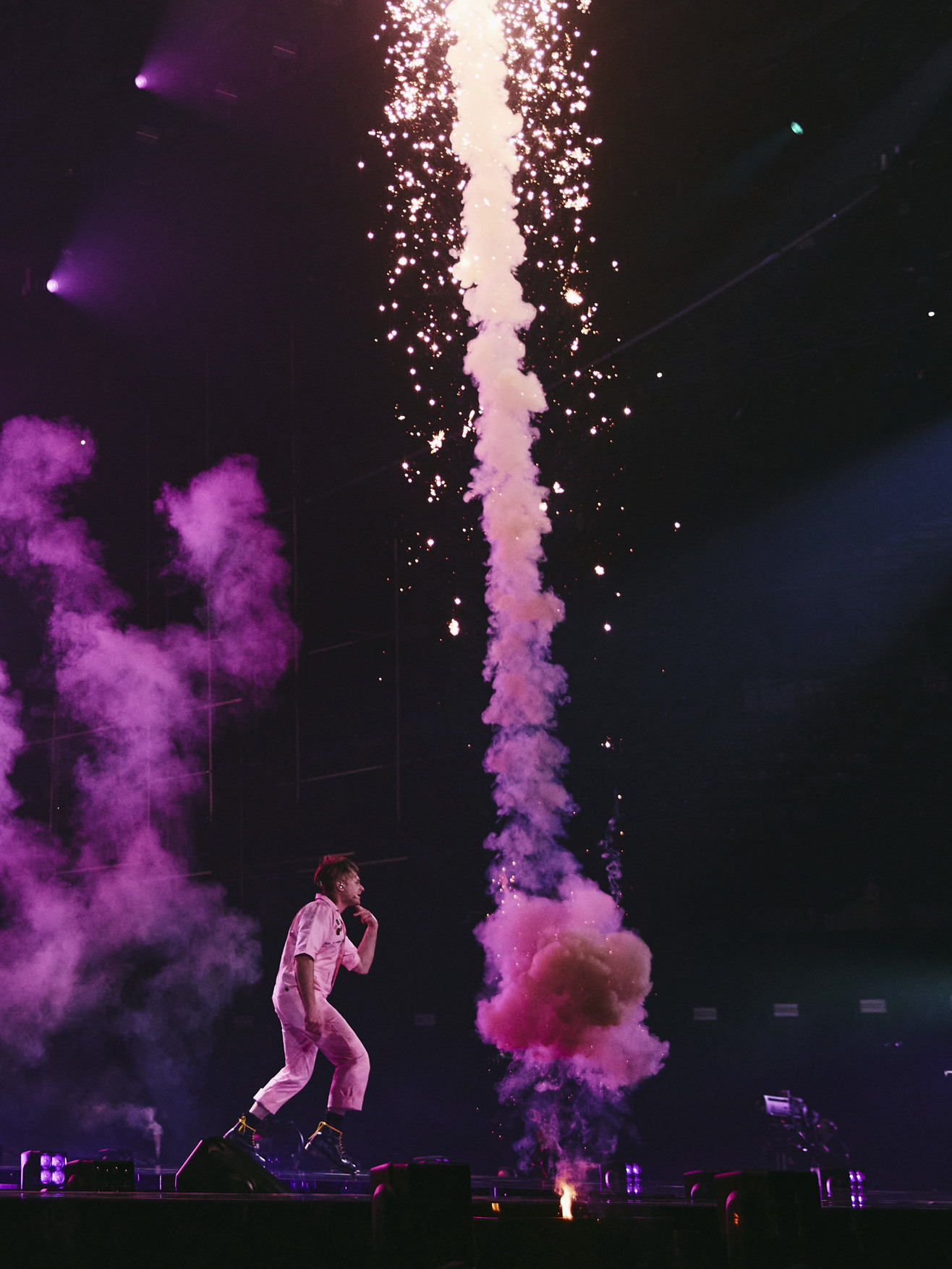 Look Mum No Computer performing on stage, next to pink smoke and a firework going off