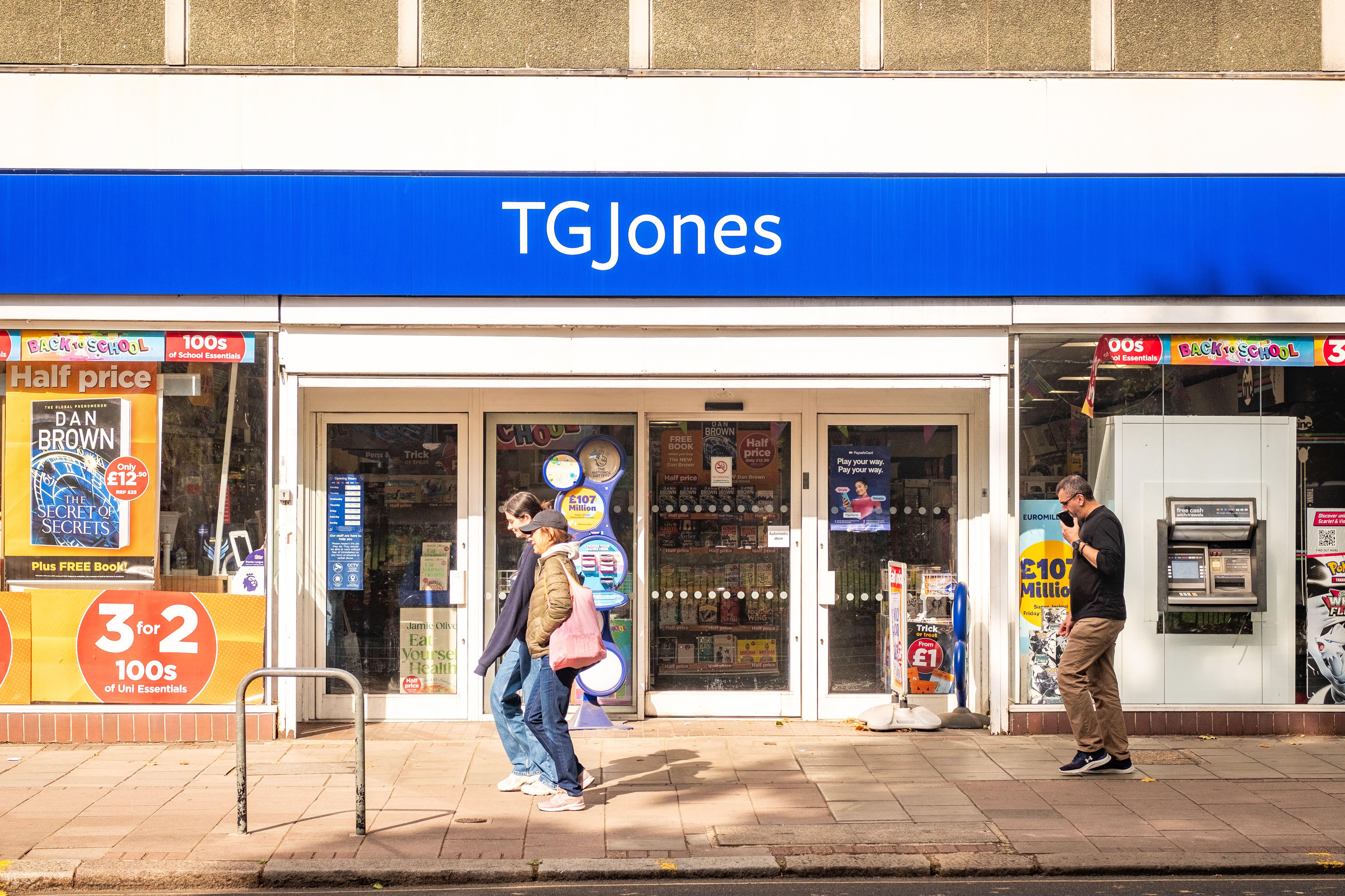 Members of the public walking past the exterior of a TG Jones shop on a high street