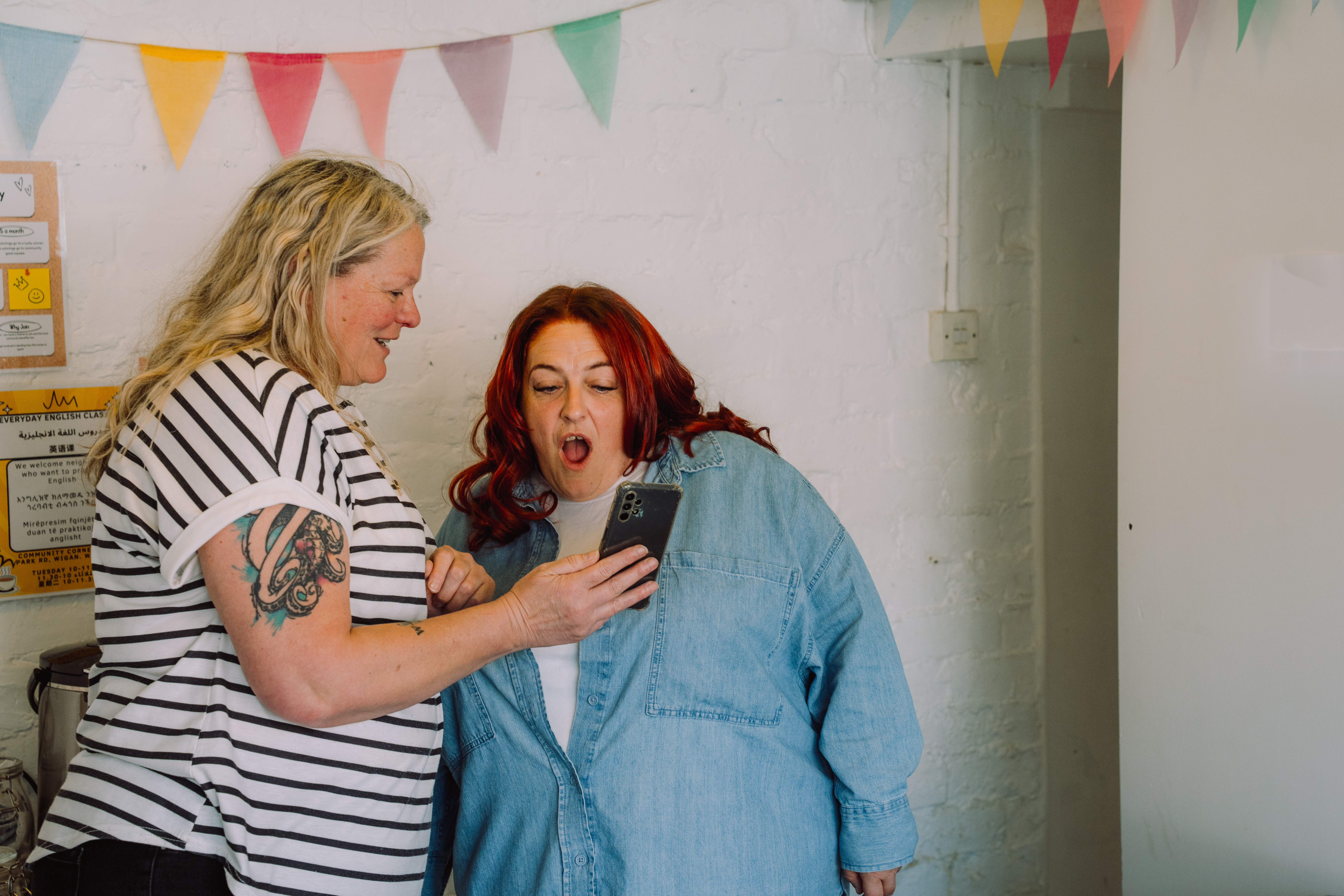Two women look at a phone