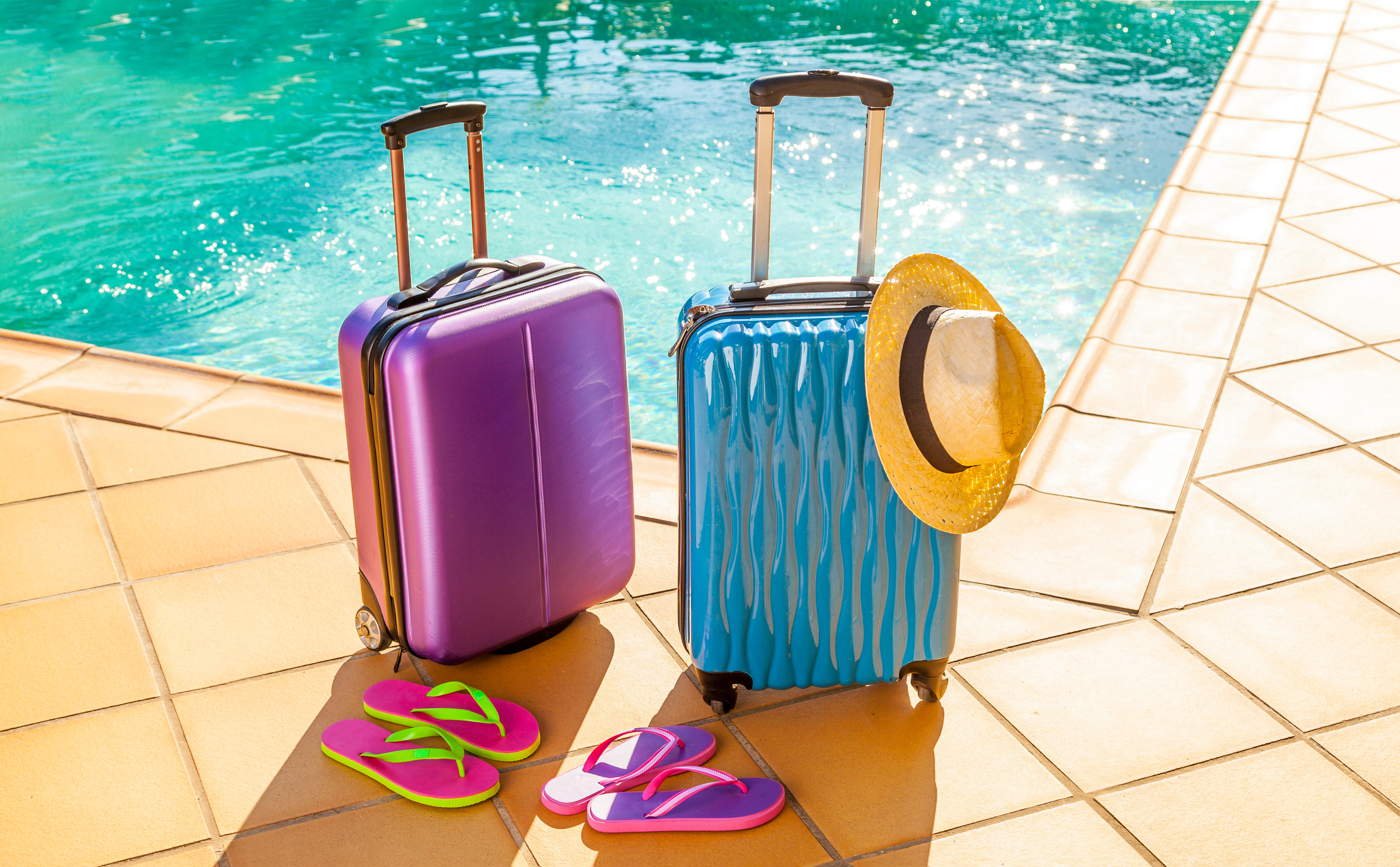 Suitcases, sandals and a hat at the pool