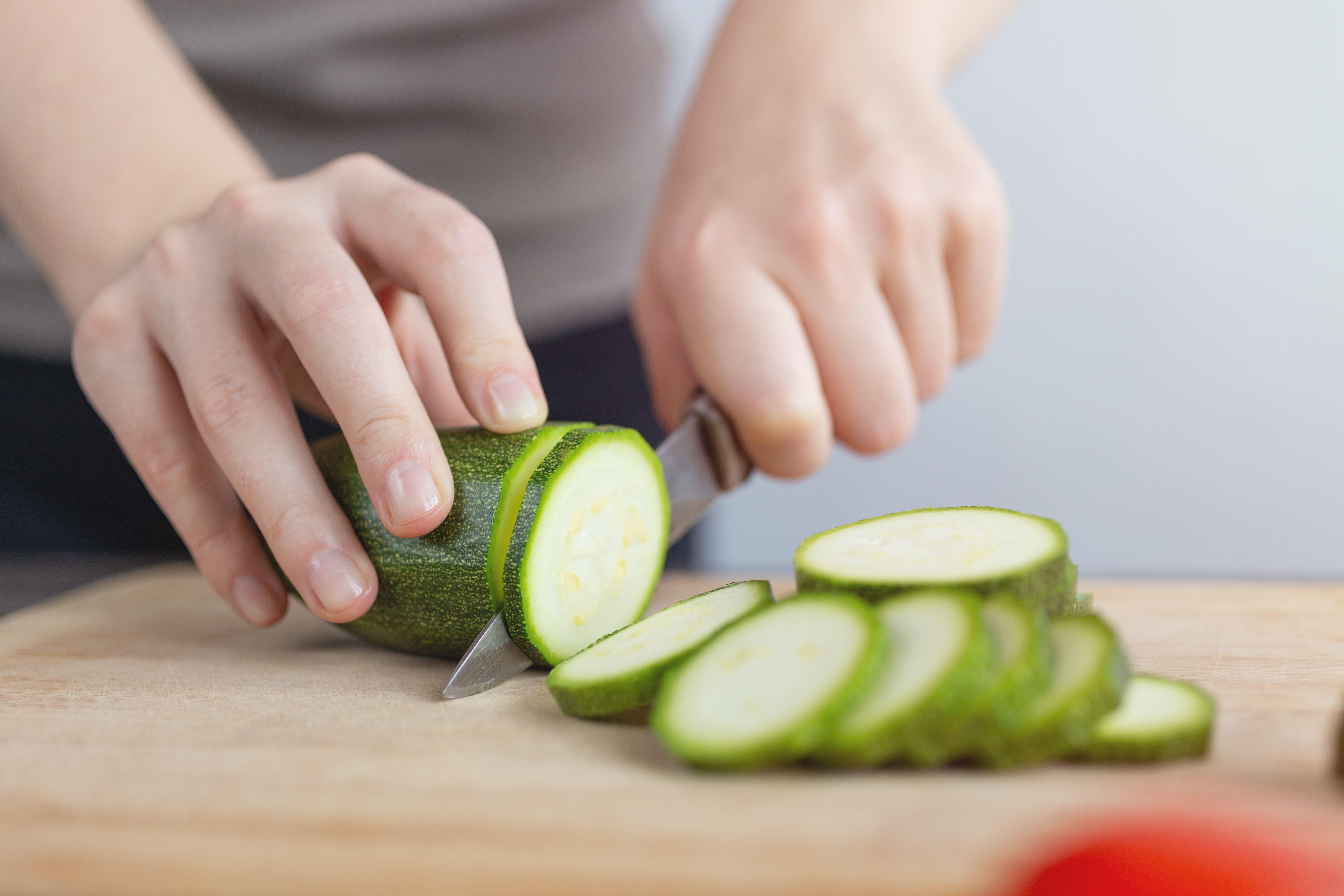  Close up picture of man cutting a courgette with a knife